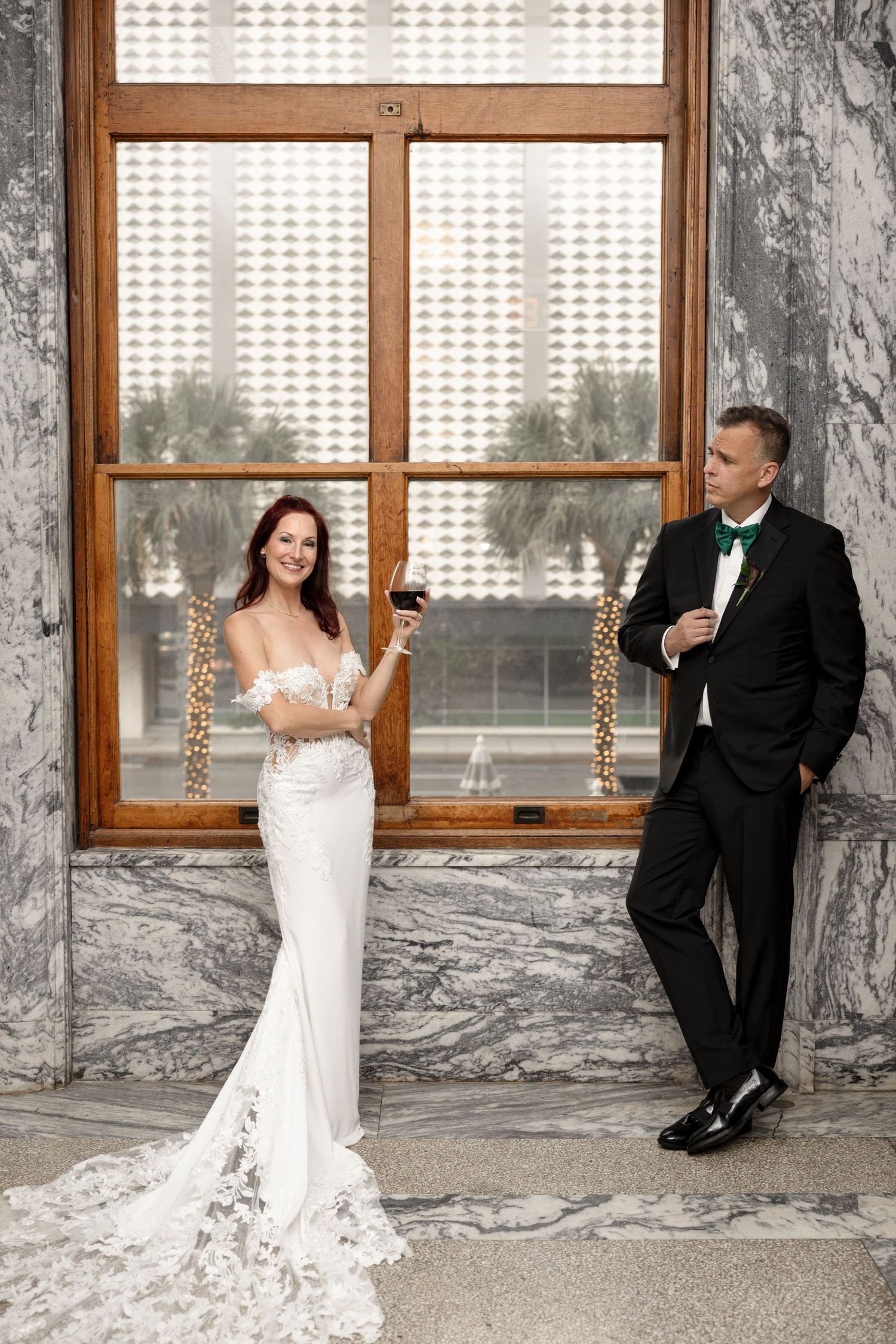 Bride and groom toasting with wine glasses in marble hall at Le Méridien Tampa, Florida, captured by Grand Photo by Karyna Oliinyk