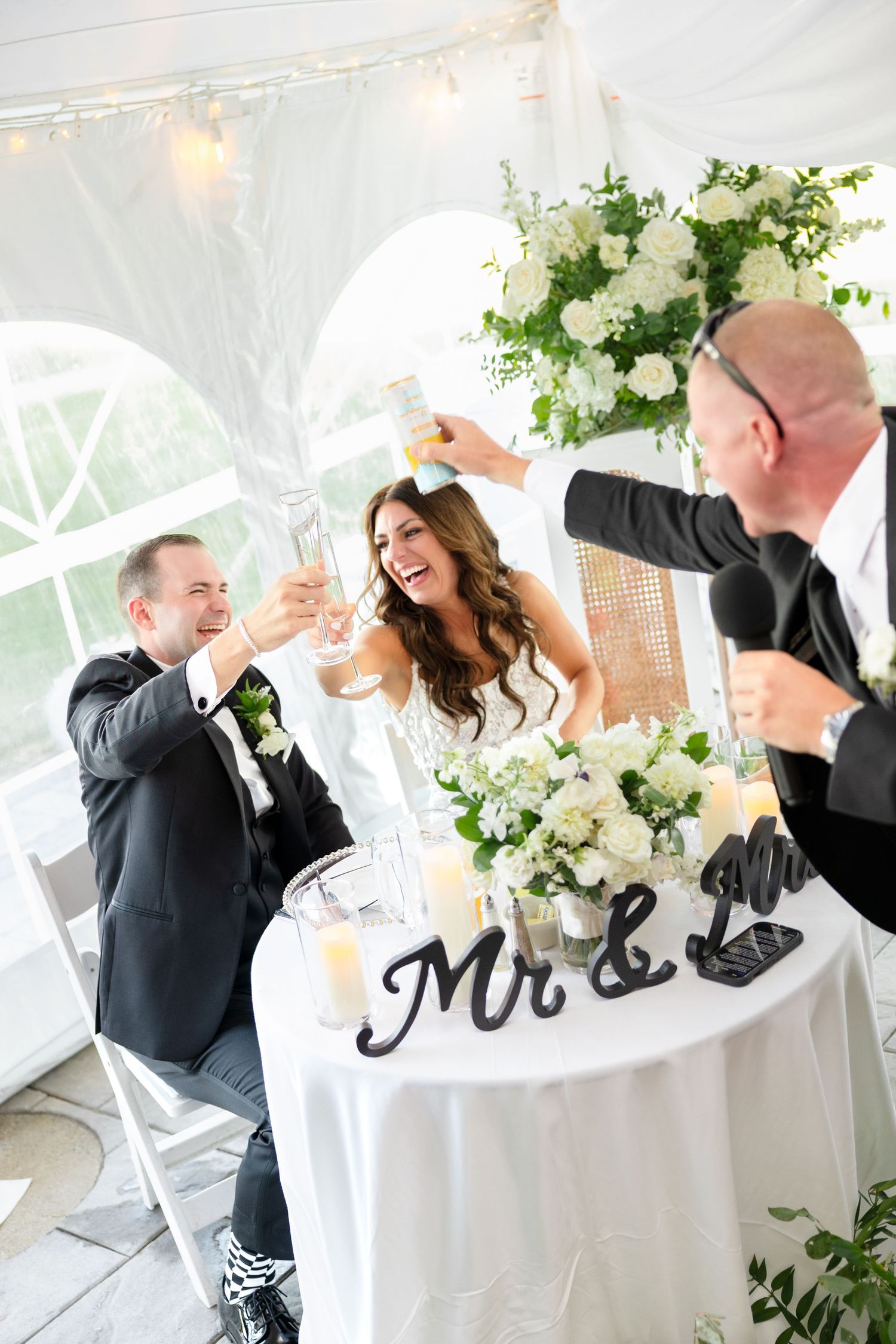 Bride and groom toast champagne with guests at sweetheart table at OceanCliff Hotel in Newport, Rhode Island, captured by Grand Photo