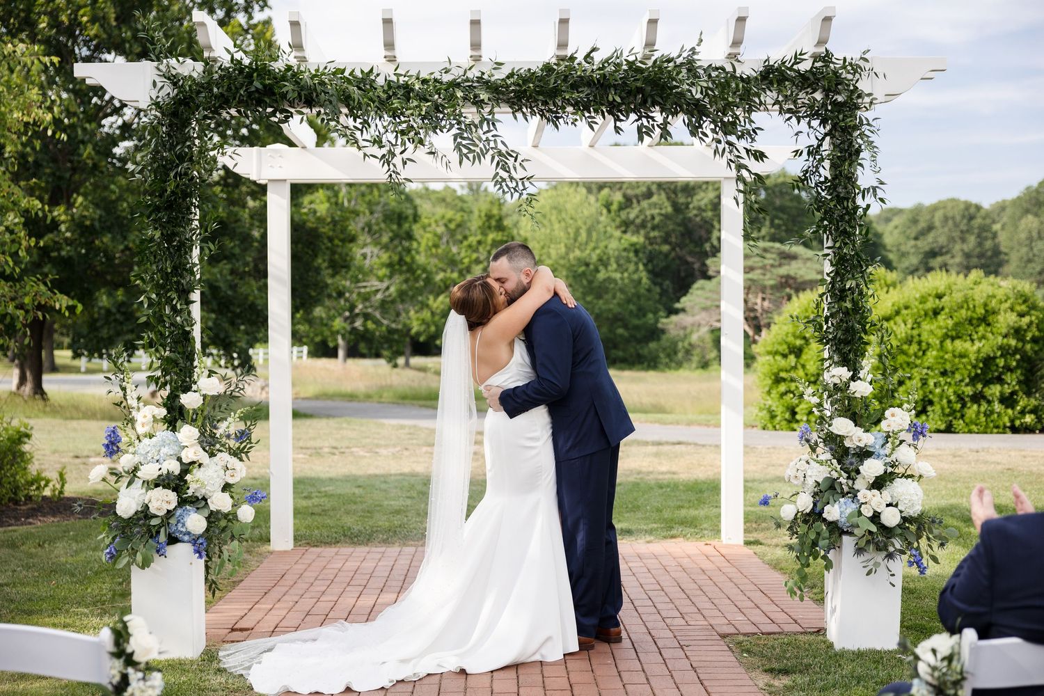 Bride and groom share first kiss at outdoor garden ceremony at Sunken Gardens St. Petersburg FL, wedding photographer Grand Photo