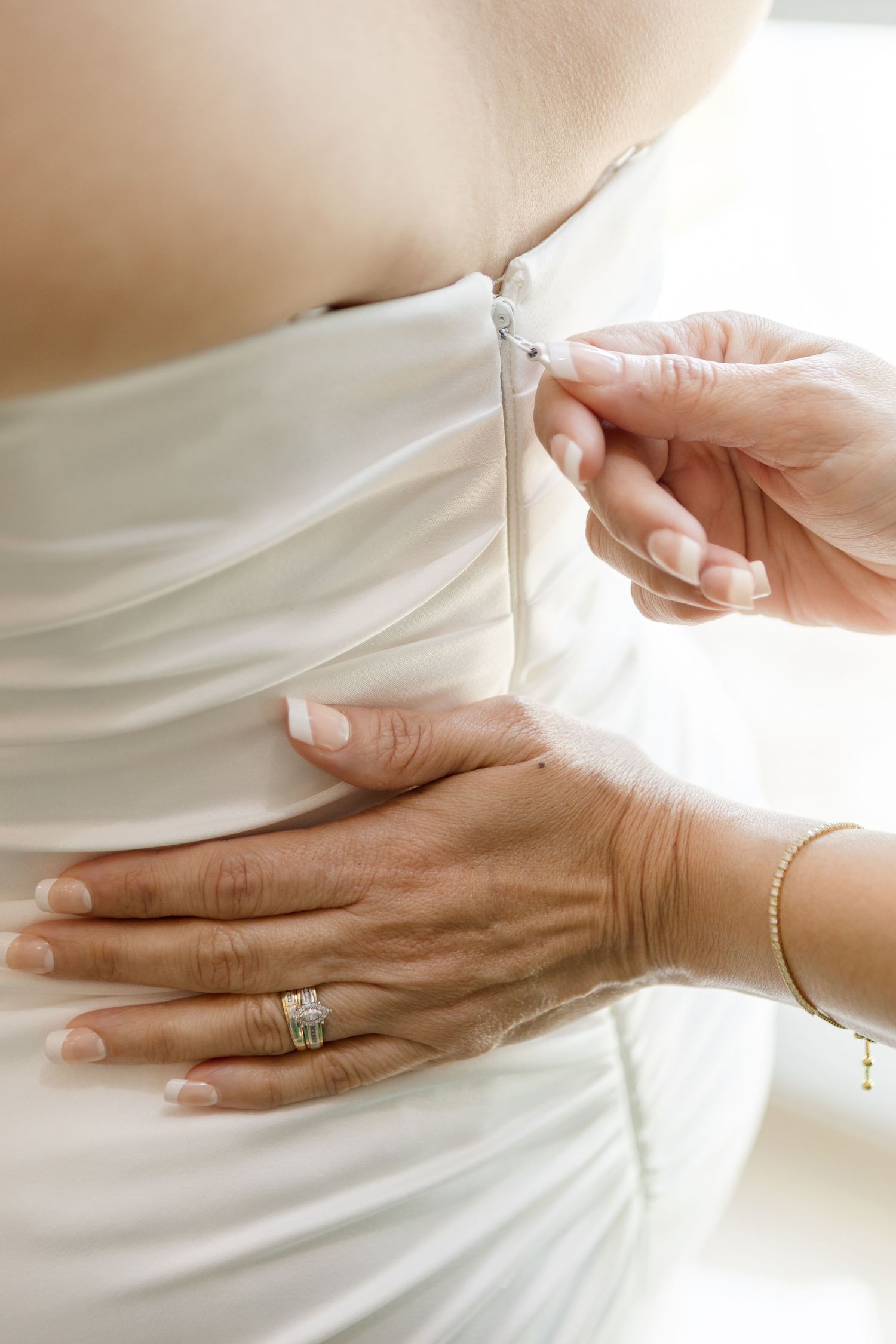 Bride putting on her wedding dress at Harborside Chapel in Safety Harbor, Florida — wedding photographer Grand Photo, Karyna Oliinyk