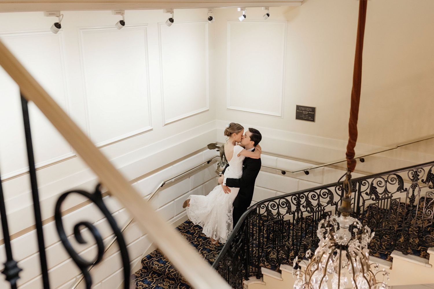 Bride and groom sharing romantic kiss on grand staircase at Hampshire House Boston MA, wedding photographer Grand Photo Karyna Oliinyk