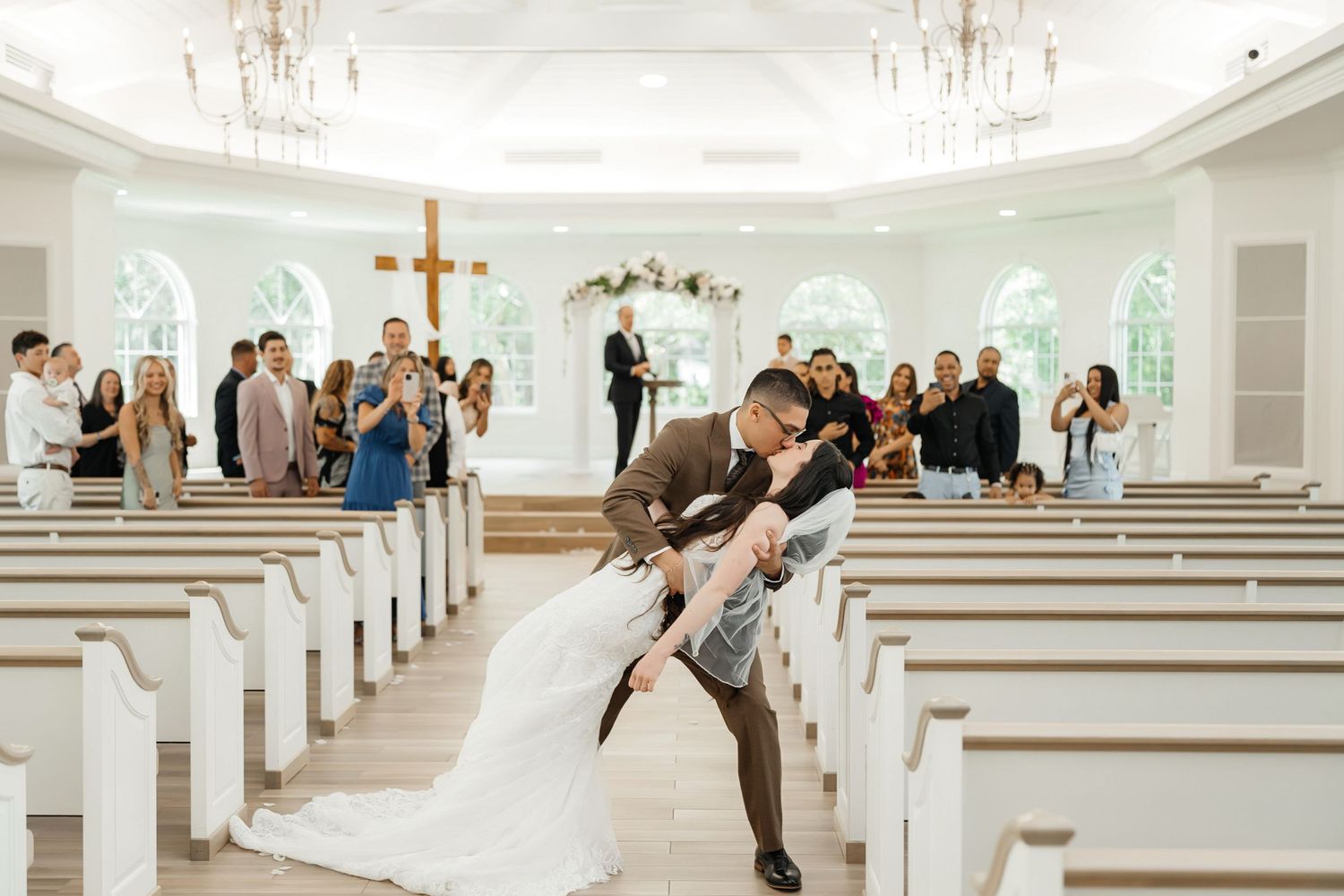 Newlyweds’ dip kiss in the aisle after the ceremony at Harborside Chapel in Safety Harbor — wedding photographer Grand Photo, Karyna Oliinyk