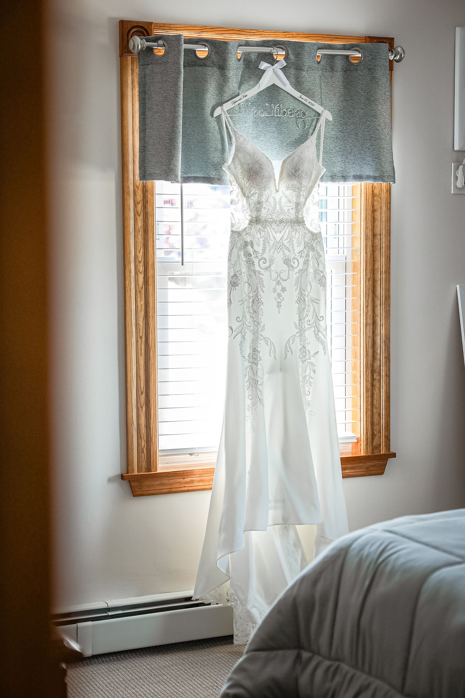 Wedding gown hanging in window light at Powel Crosley Estate in Sarasota, Florida, captured by Grand Photo by Karyna Oliinyk