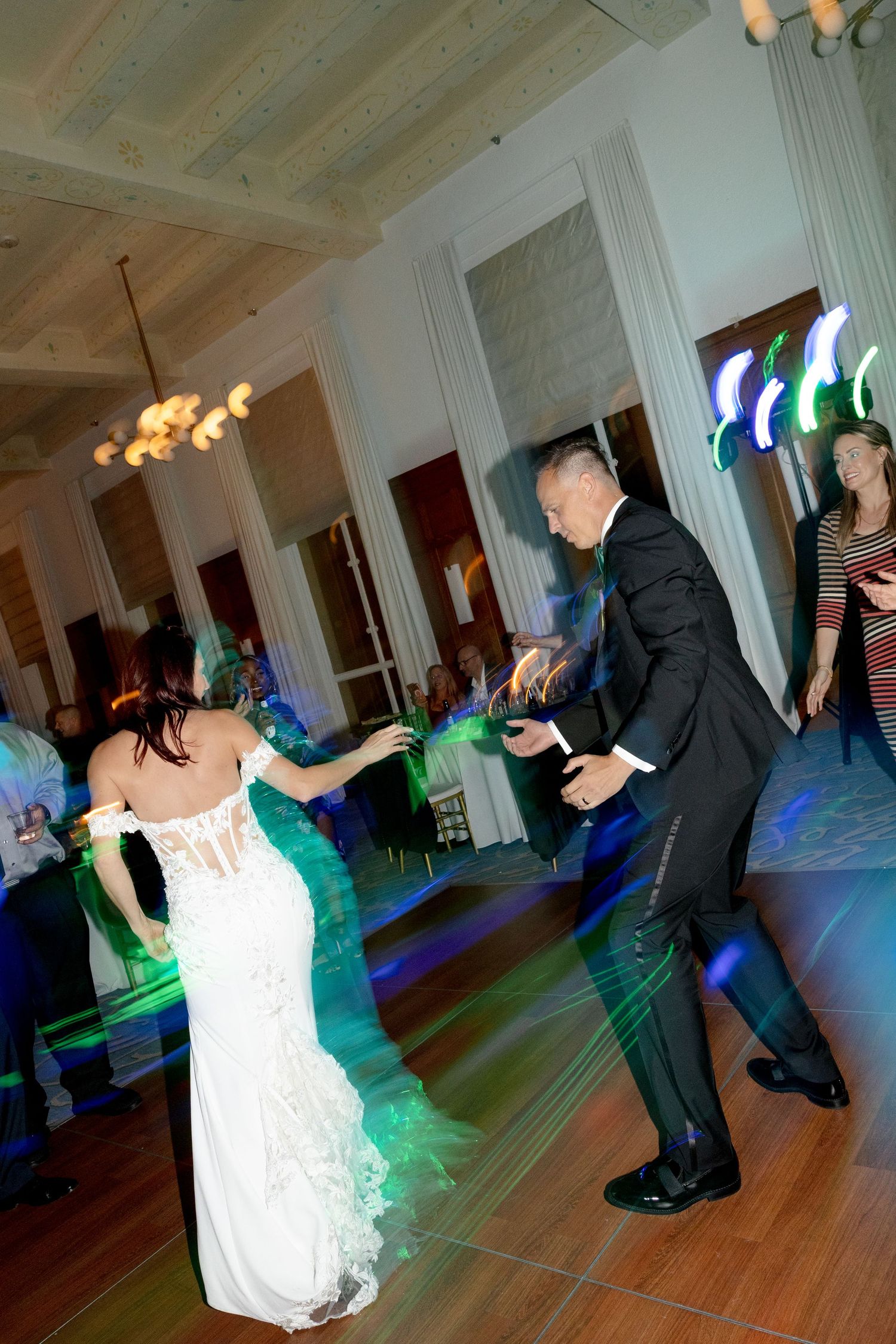 Bride and groom dancing under colorful lights on wedding reception at Le Méridien Tampa, Florida, captured by Grand Photo by Karyna Oliinyk