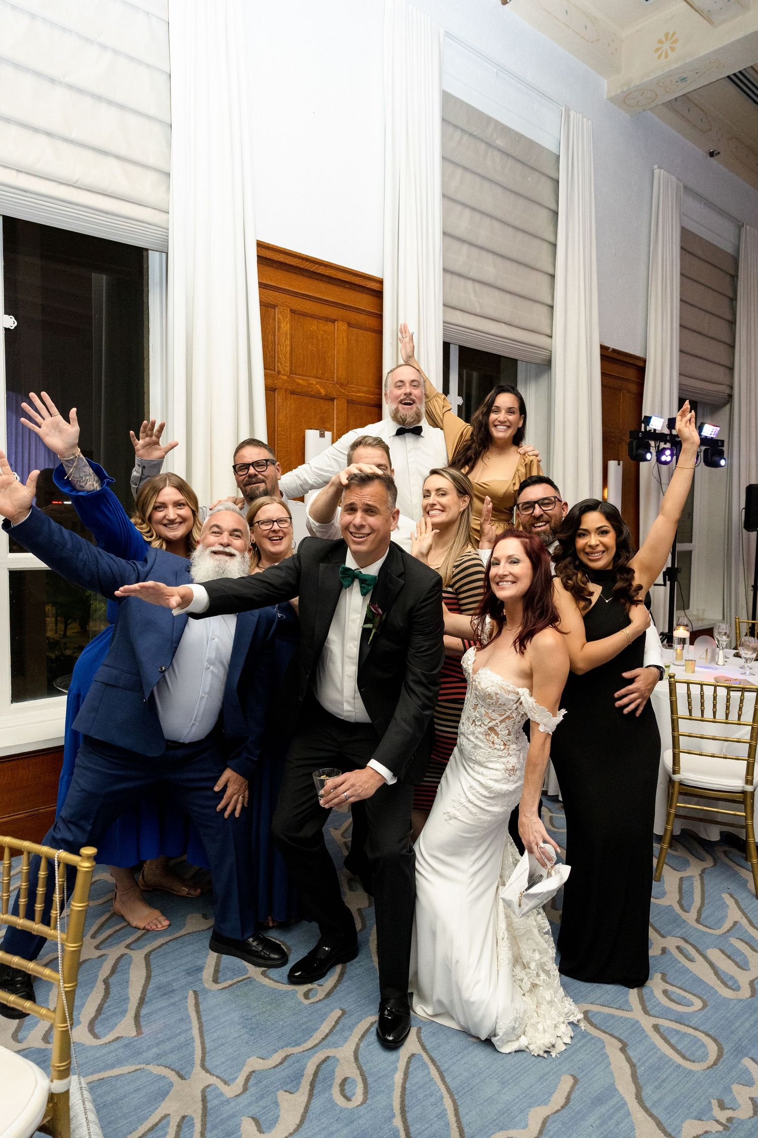 Wedding party guests celebrate joyfully with raised arms at Le Méridien Tampa, Florida, captured by Grand Photo by Karyna Oliinyk