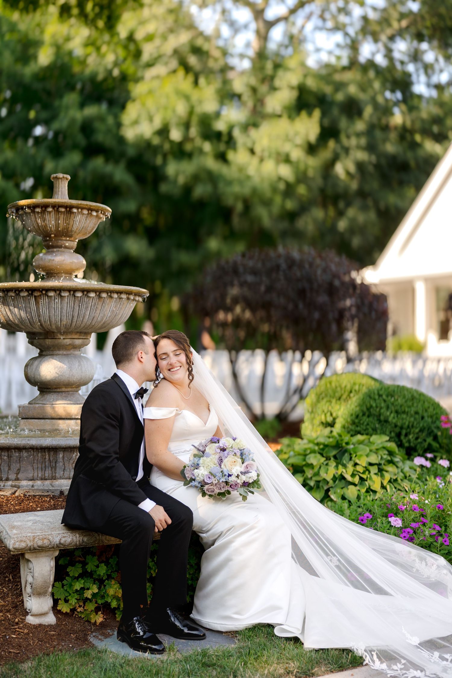 Bride and groom sitting by fountain in garden at Saphire Estate in Sharon, Massachusetts, captured by Grand Photo by Karyna Oliinyk