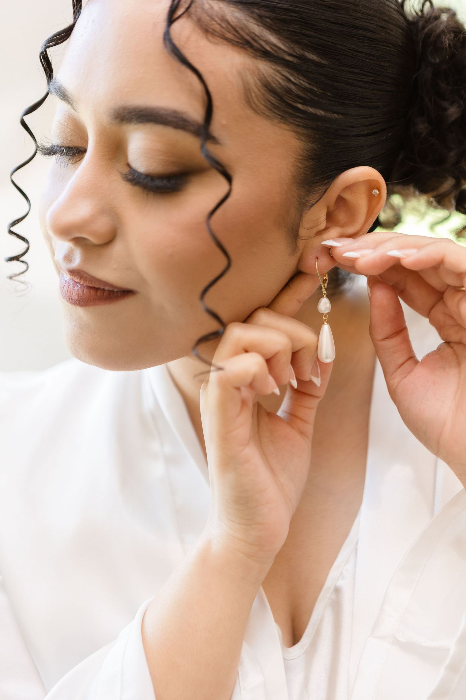 Bride putting on earrings before ceremony at Harborside Chapel in Safety Harbor, Florida — wedding photographer Grand Photo, Karyna Oliinyk