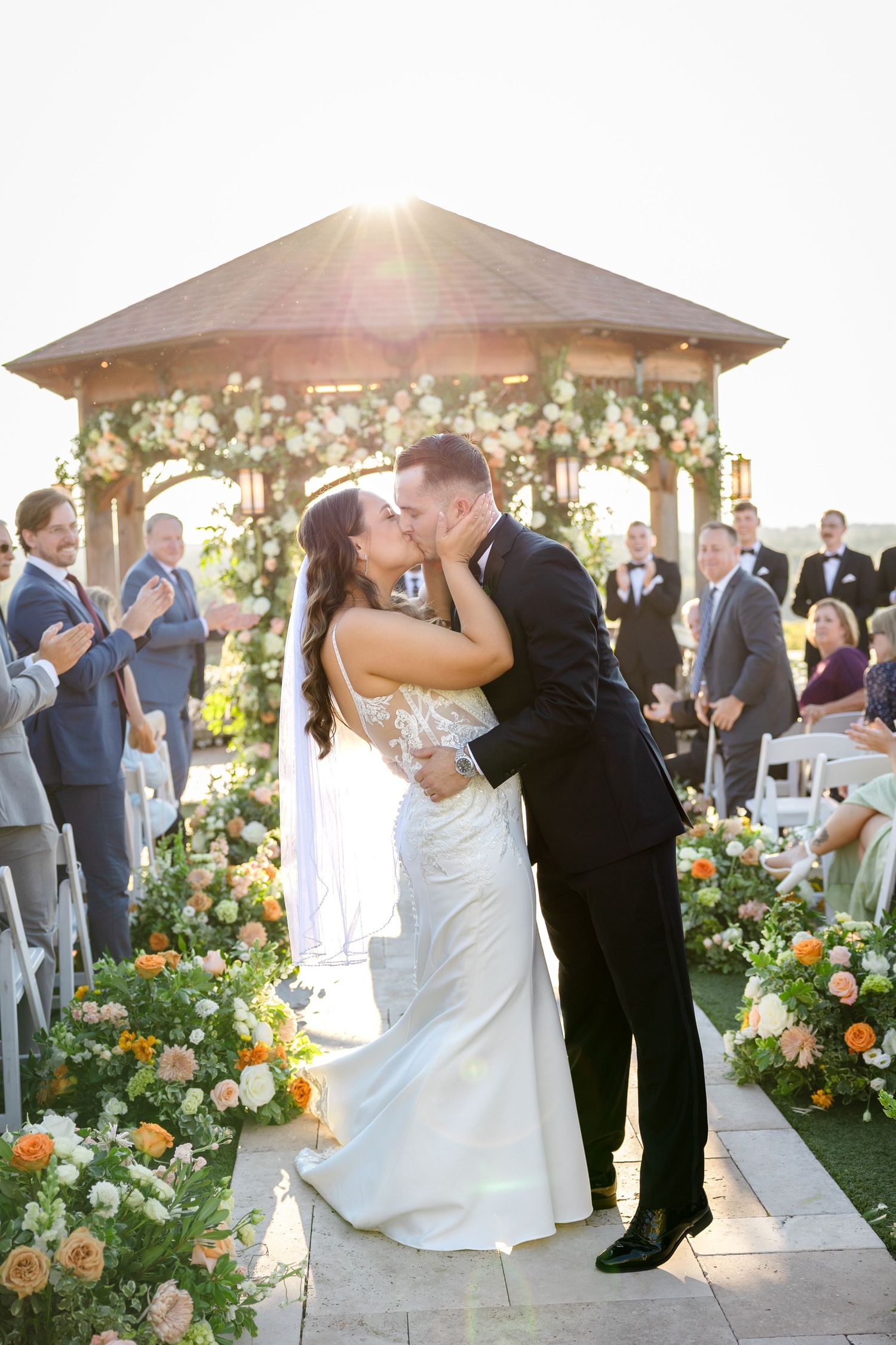 Bride and groom share first kiss at sunset outdoor ceremony at The Great Horse in Hampden, Massachusetts, captured by Grand Photo by Karyna