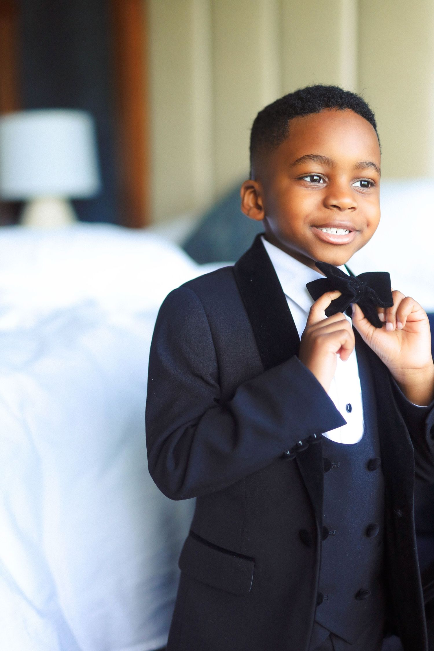 Ring bearer adjusting bow tie at The Tampa EDITION in Tampa, Florida, captured by Grand Photo by Karyna Oliinyk
