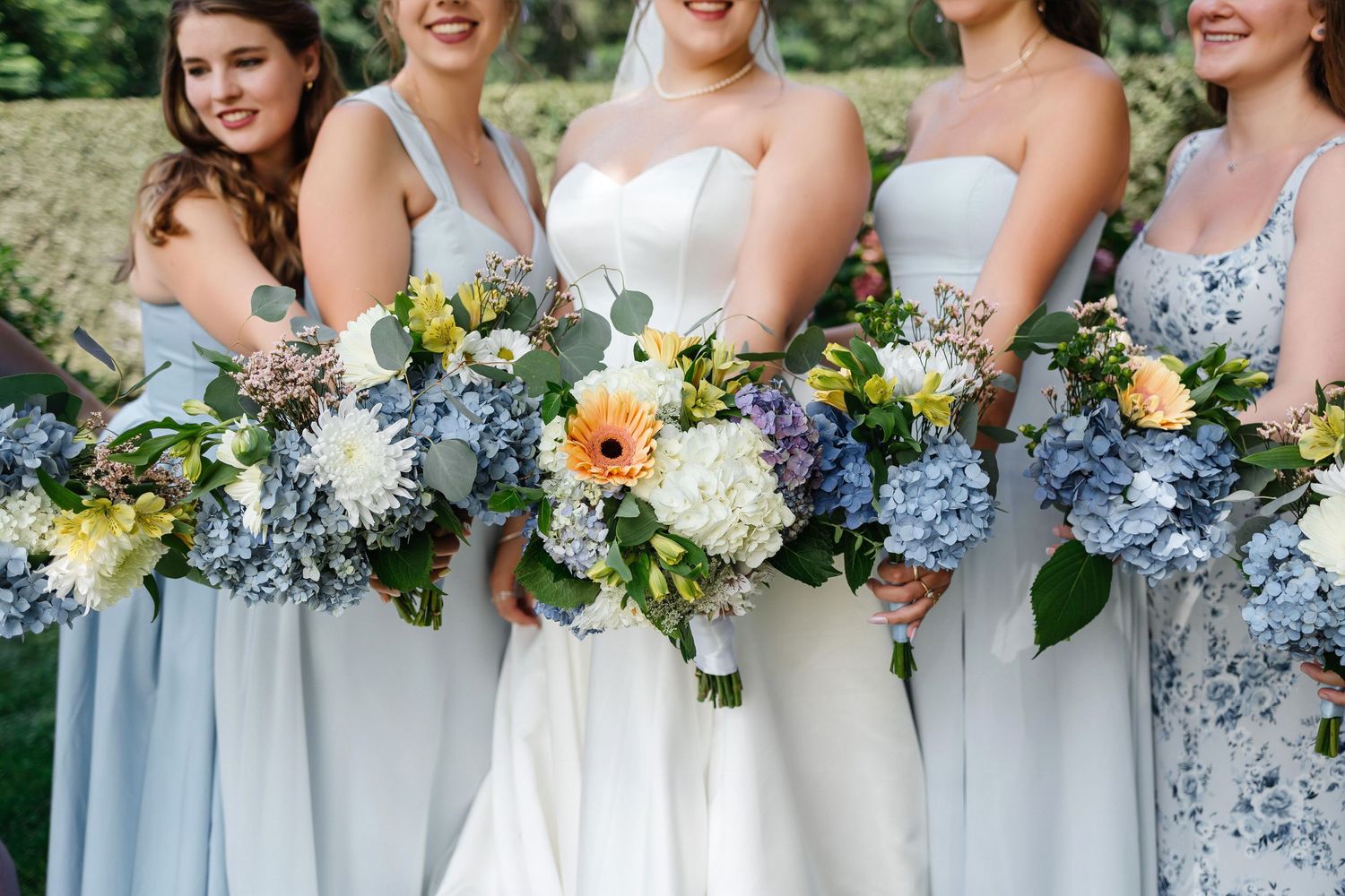 Bride and bridesmaids in light blue dresses with bouquets at The Birchwood Hotel St. Petersburg FL, wedding photographer Grand Photo