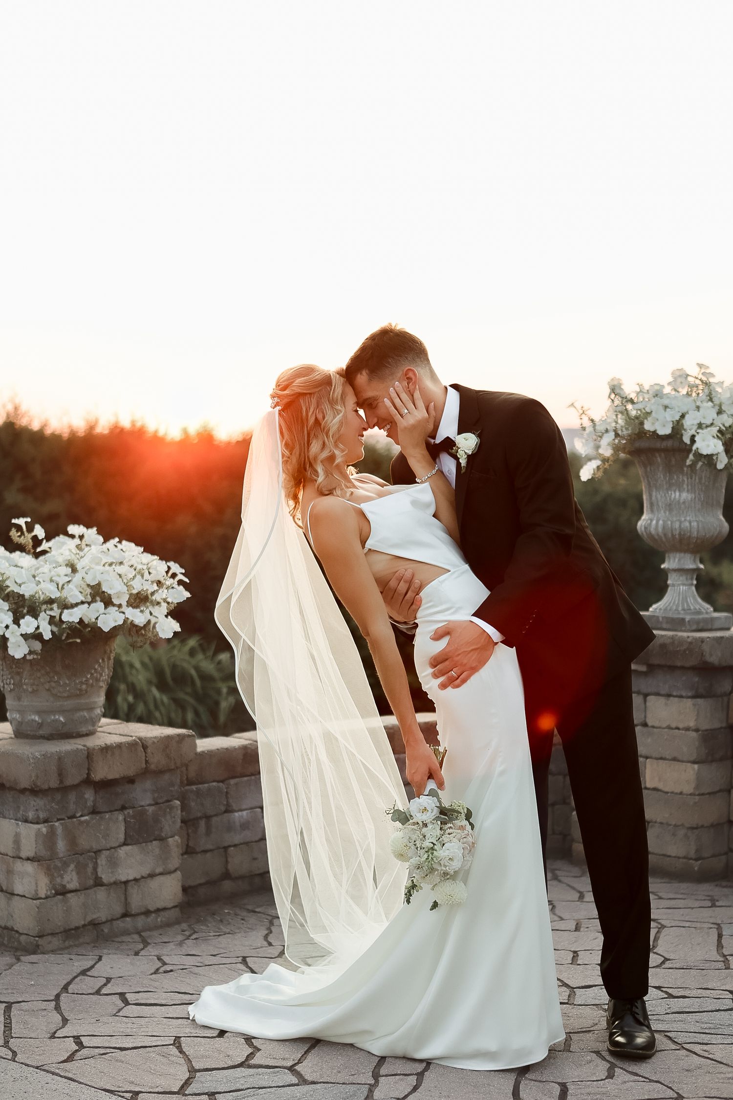 Bride and groom sharing a romantic sunset kiss at The Log Cabin in Holyoke, Massachusetts, captured by Grand Photo by Karyna Oliinyk