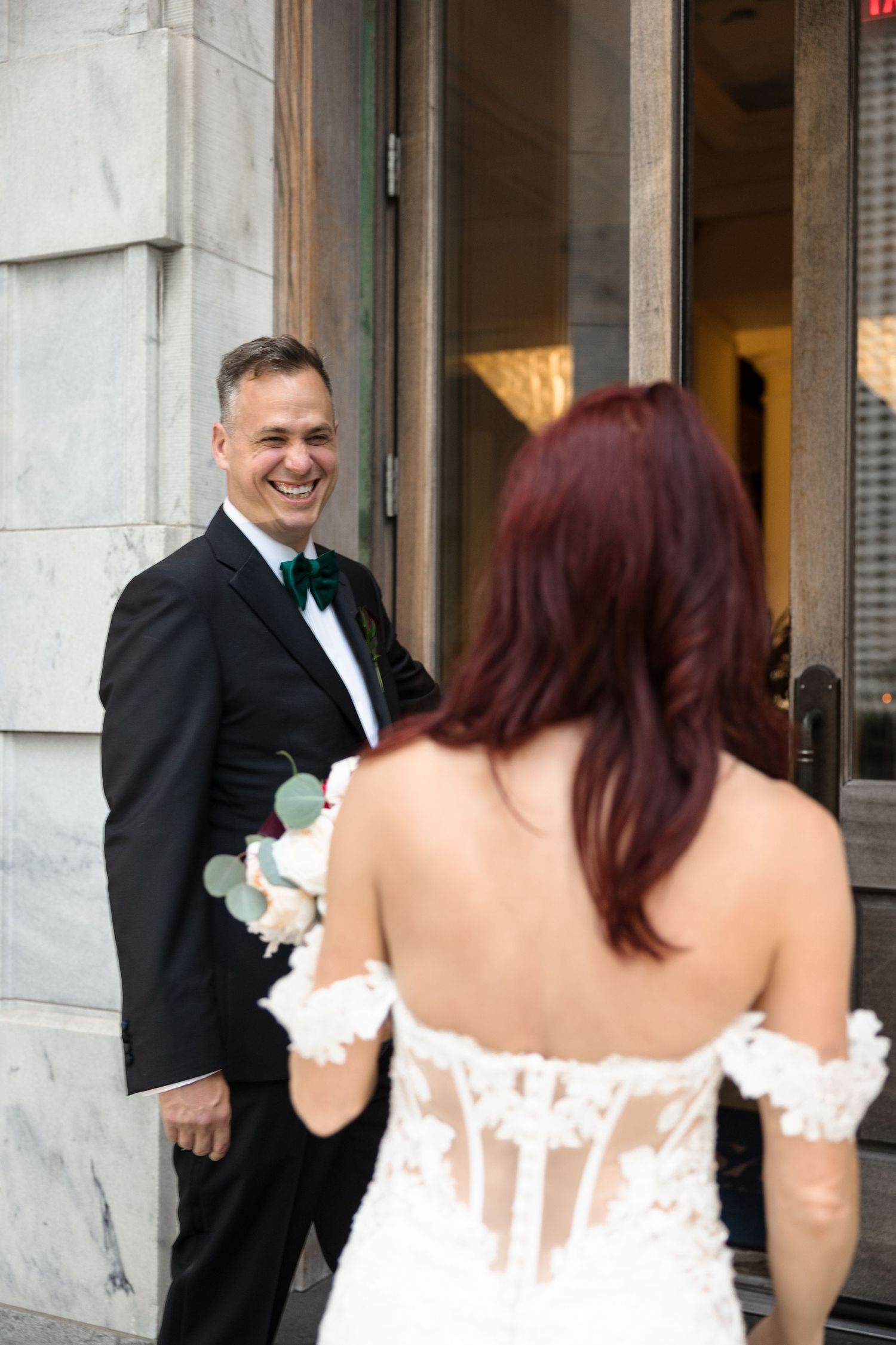 Groom laughing as bride approaches during wedding first look at Le Méridien Tampa, Florida, captured by Grand Photo by Karyna Oliinyk