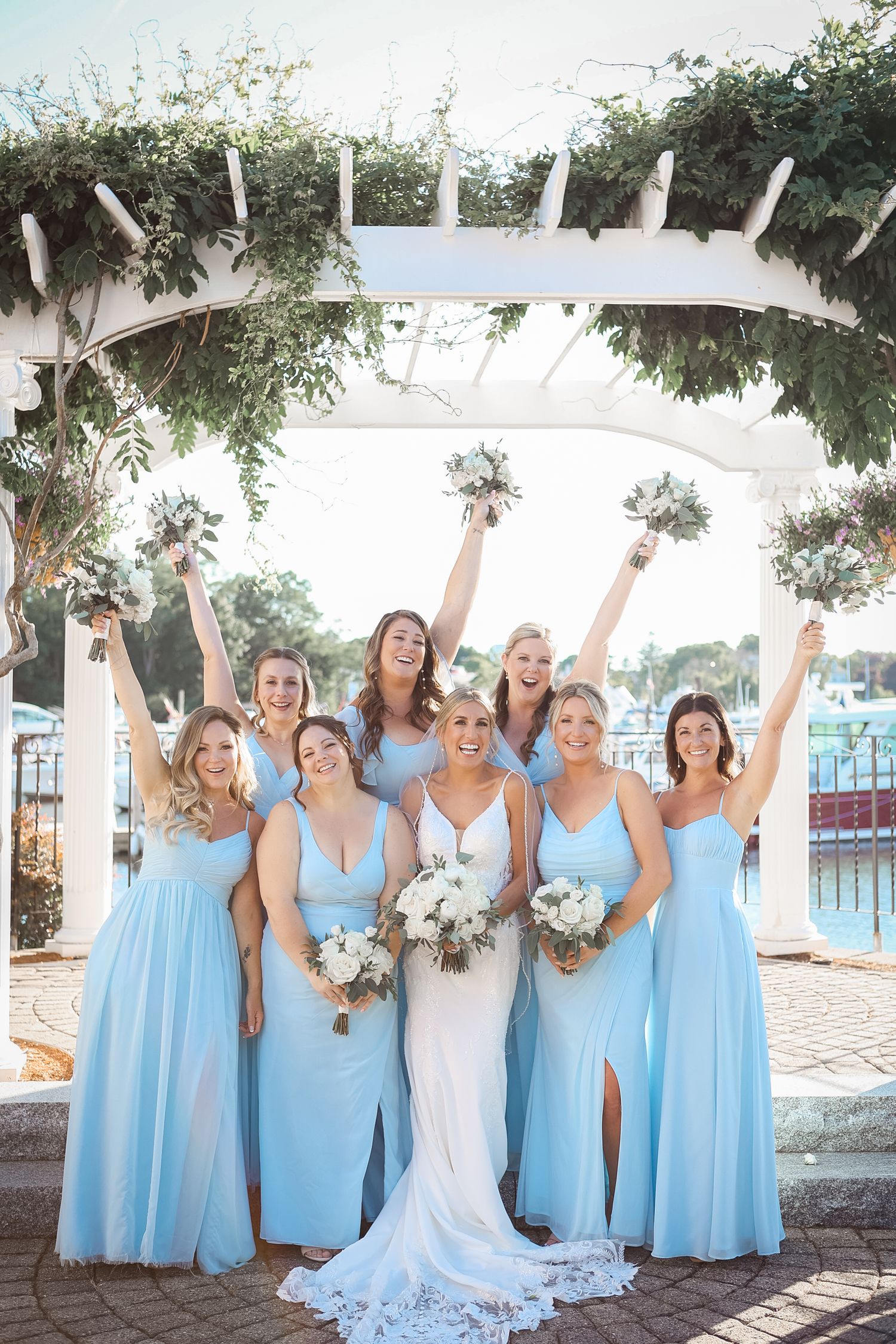Bride with bridesmaids in light blue gowns at Danversport in Danvers, Massachusetts, captured by Grand Photo by Karyna Oliinyk