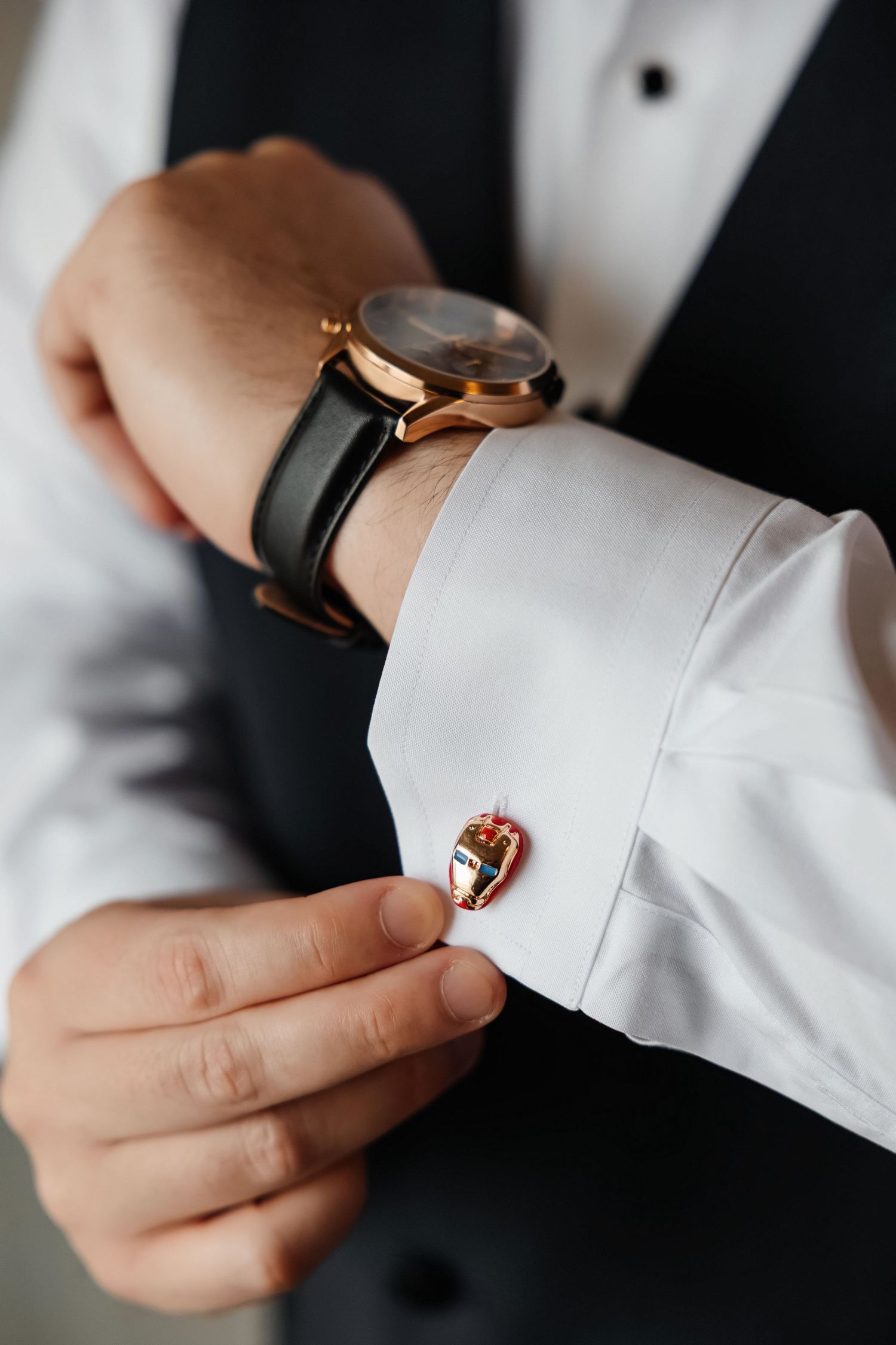 Groom adjusts colorful cufflinks at Saphire Estate in Sharon, Massachusetts, captured by Grand Photo by Karyna Oliinyk