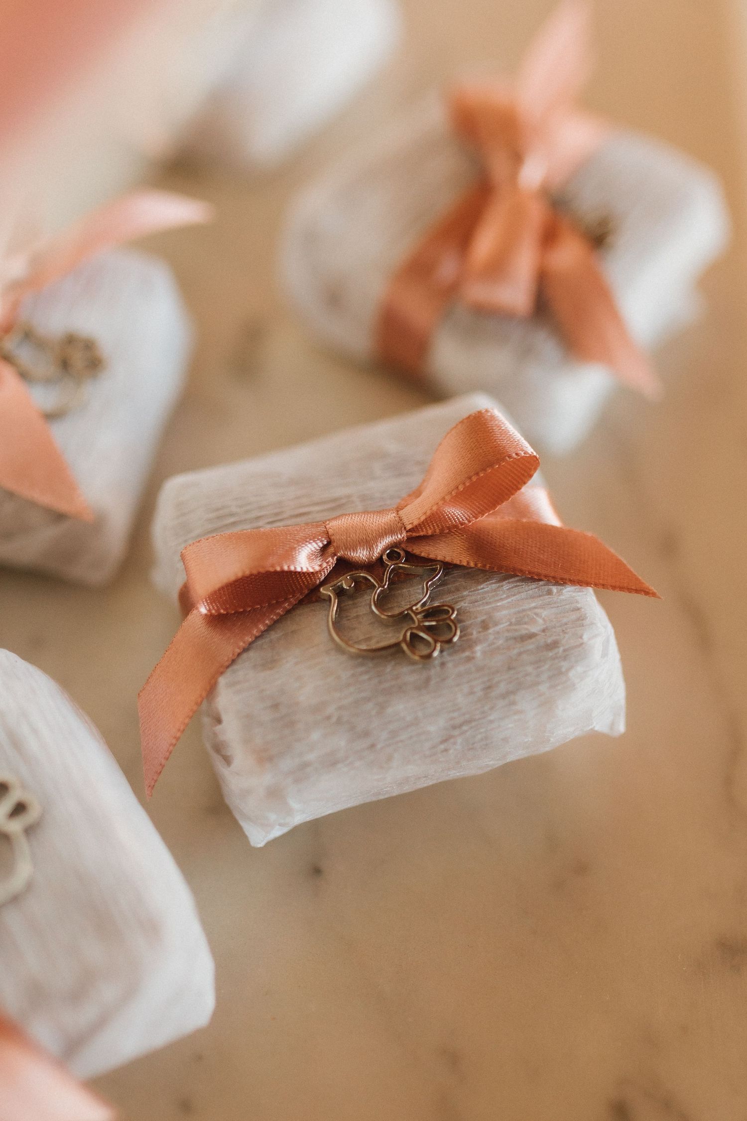 Elegant christening favor gifts wrapped in white with copper satin bows and bronze dove charms.