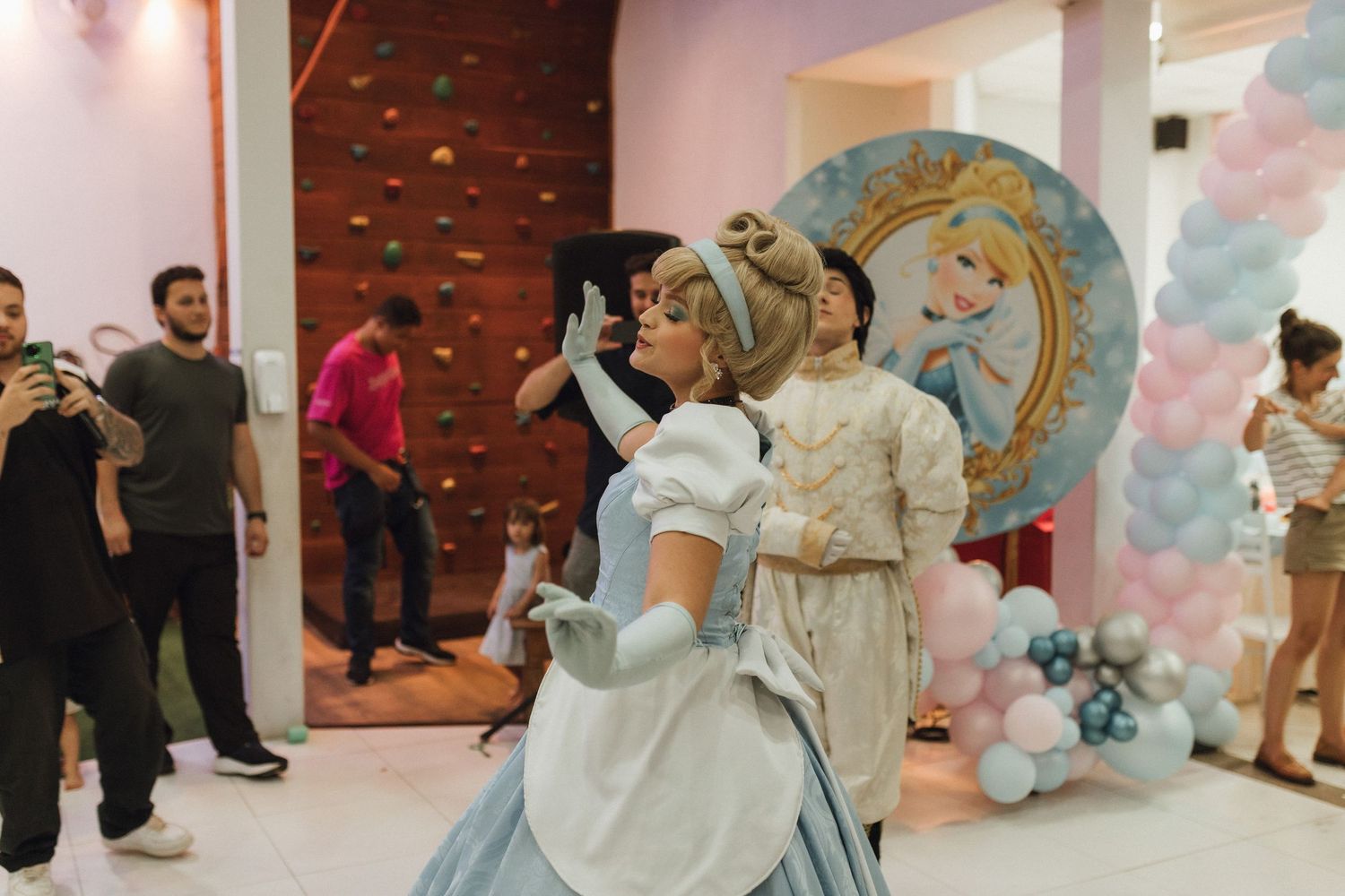 Cinderella princess character dancing with guest at a fairy tale themed birthday party celebration.