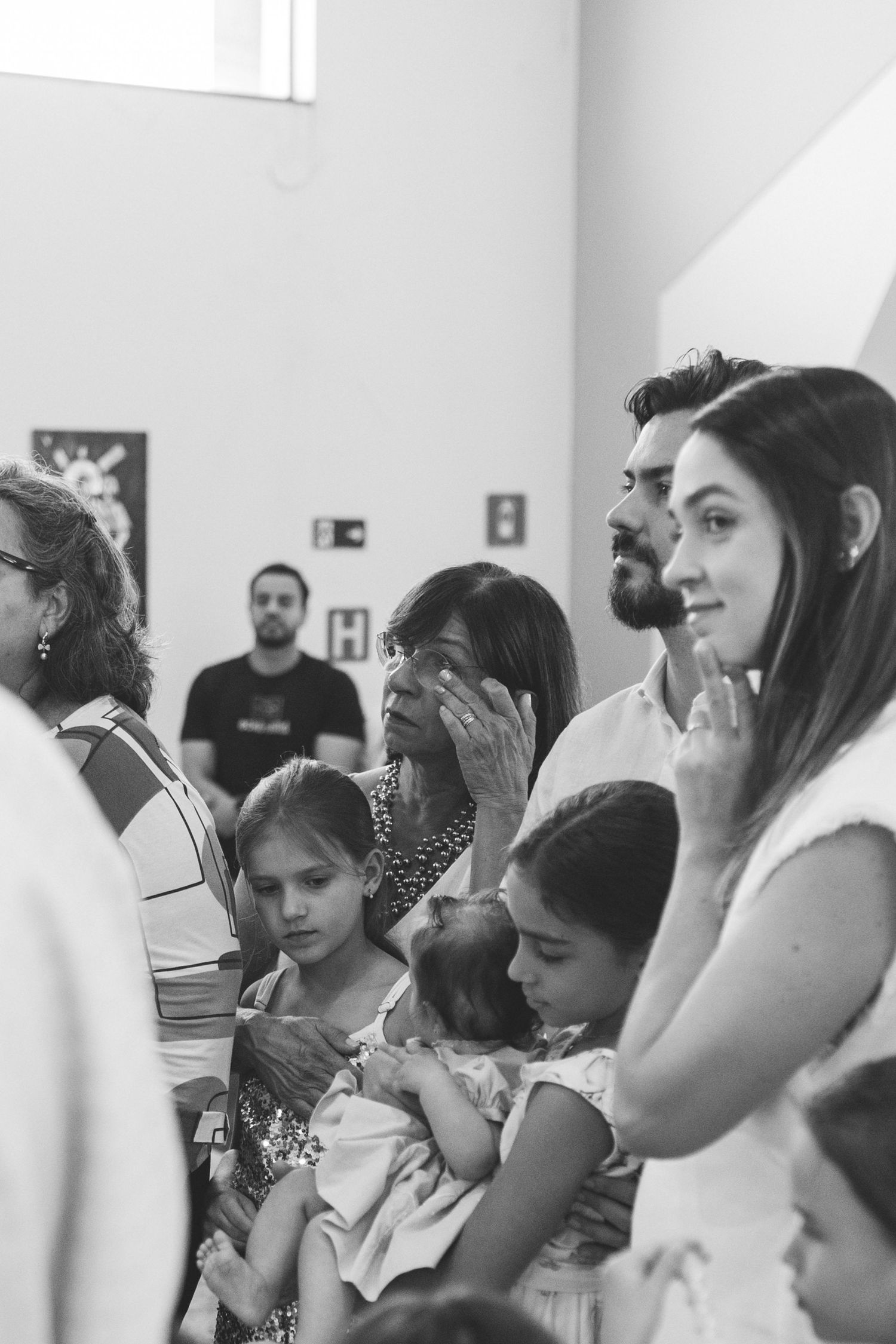 Black and white photo of families gathered at a religious ceremony, emotional crowd with children.