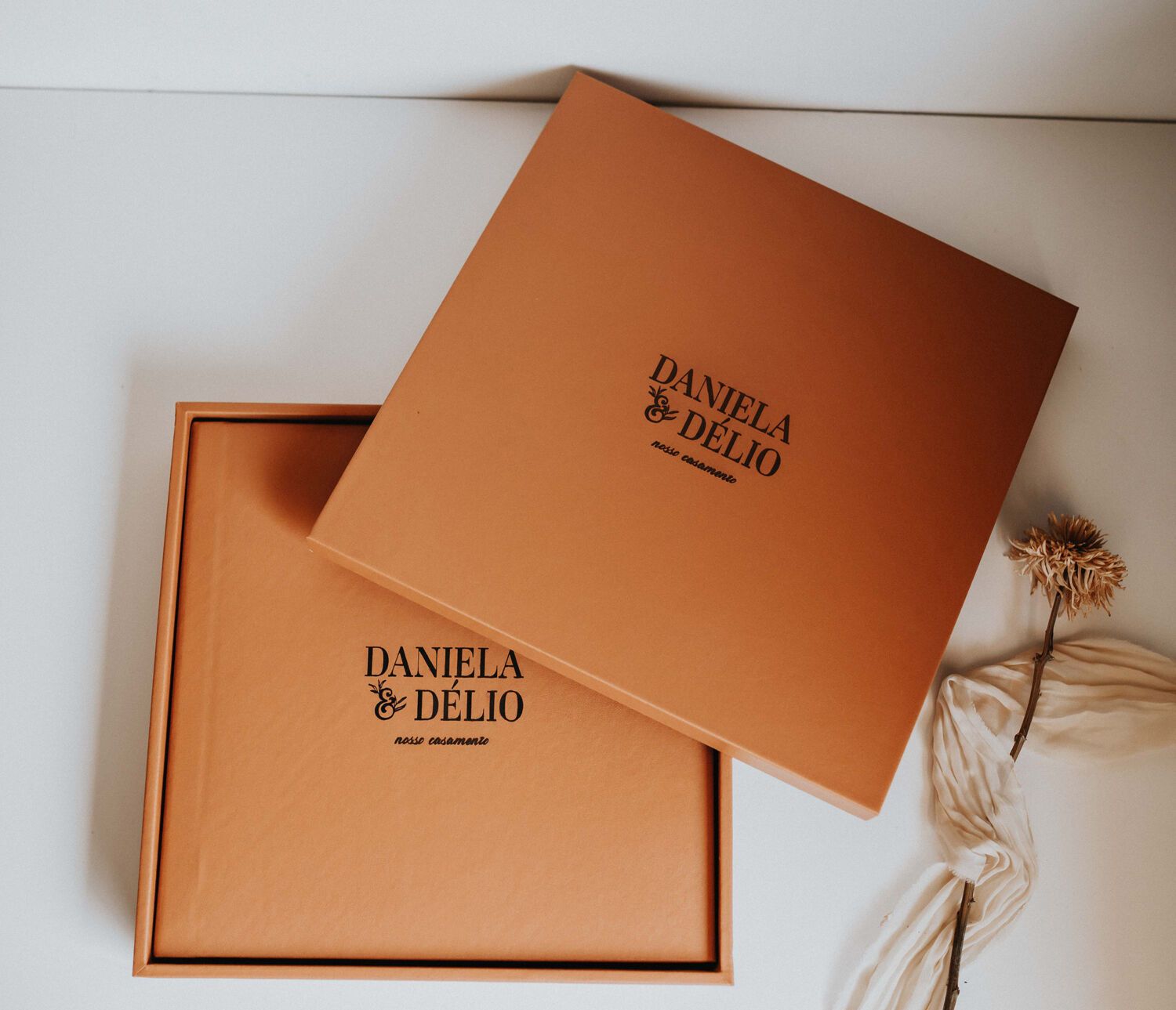 Daniela & Delio branded luxury gift box with lid, in warm terracotta tone, displayed on white surface.