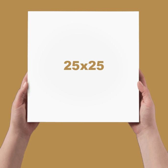 Hands holding a white 25x25 square photo book against a warm golden background.