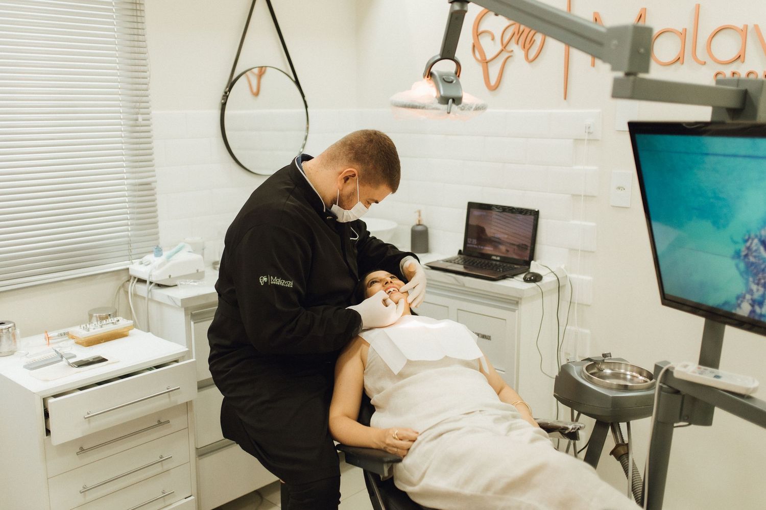 Esthetician performing a facial treatment on a client in a modern beauty salon with professional skincare equipment.