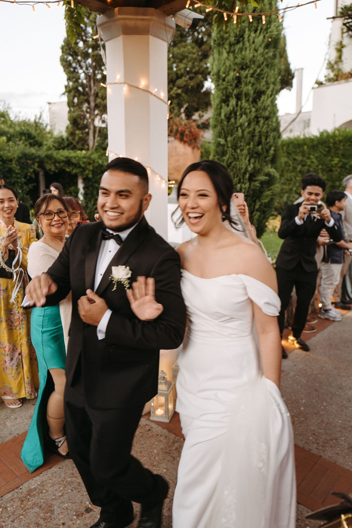 Newlyweds walking while greeting guests in Ravello, Italy near the Amalfi Coast on their wedding day.