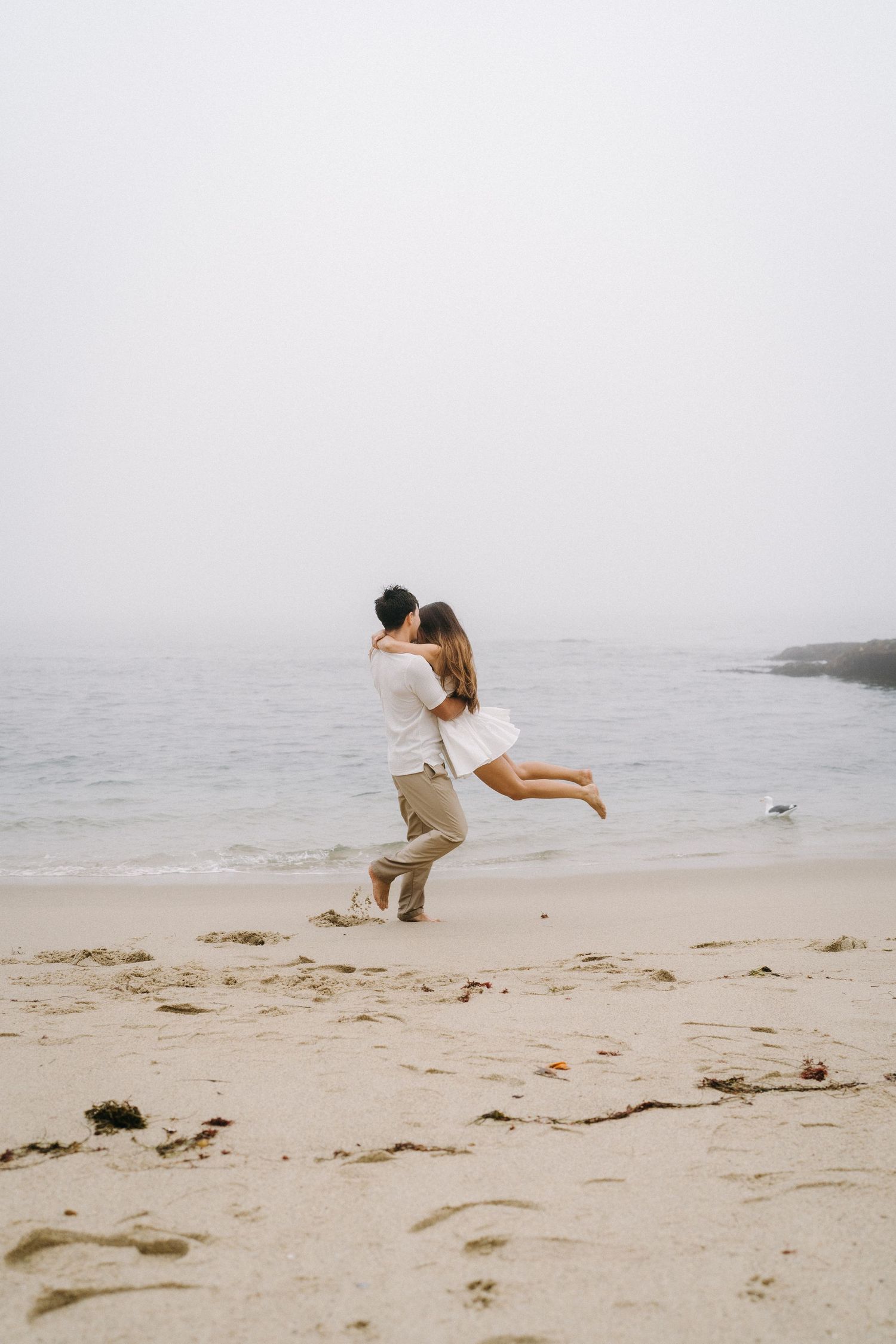 Man lifting his fiancé during an engagement session in Laguna Beach.