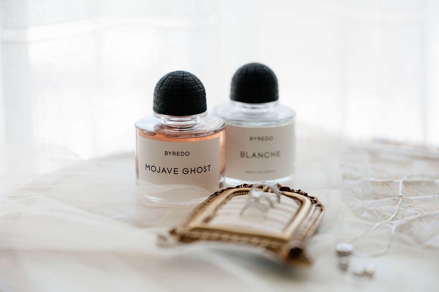 Detail shot of wedding rings and perfume.