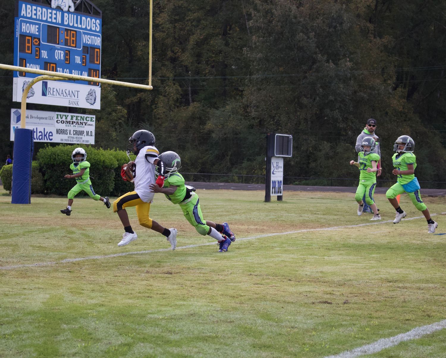Little league player making an attempt at a tackle.