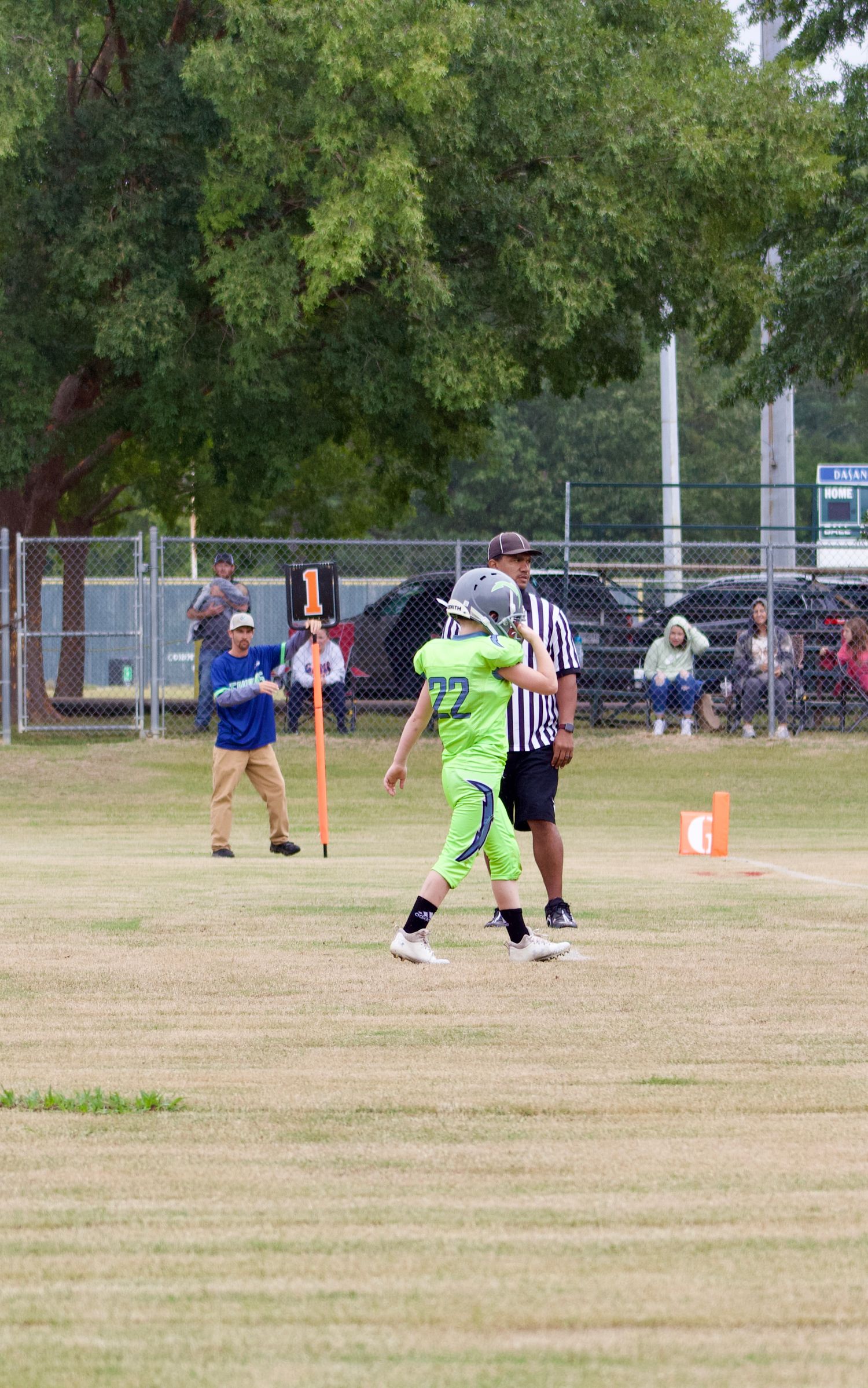 Little league travel football player crossing the field to continue the play on the offense.