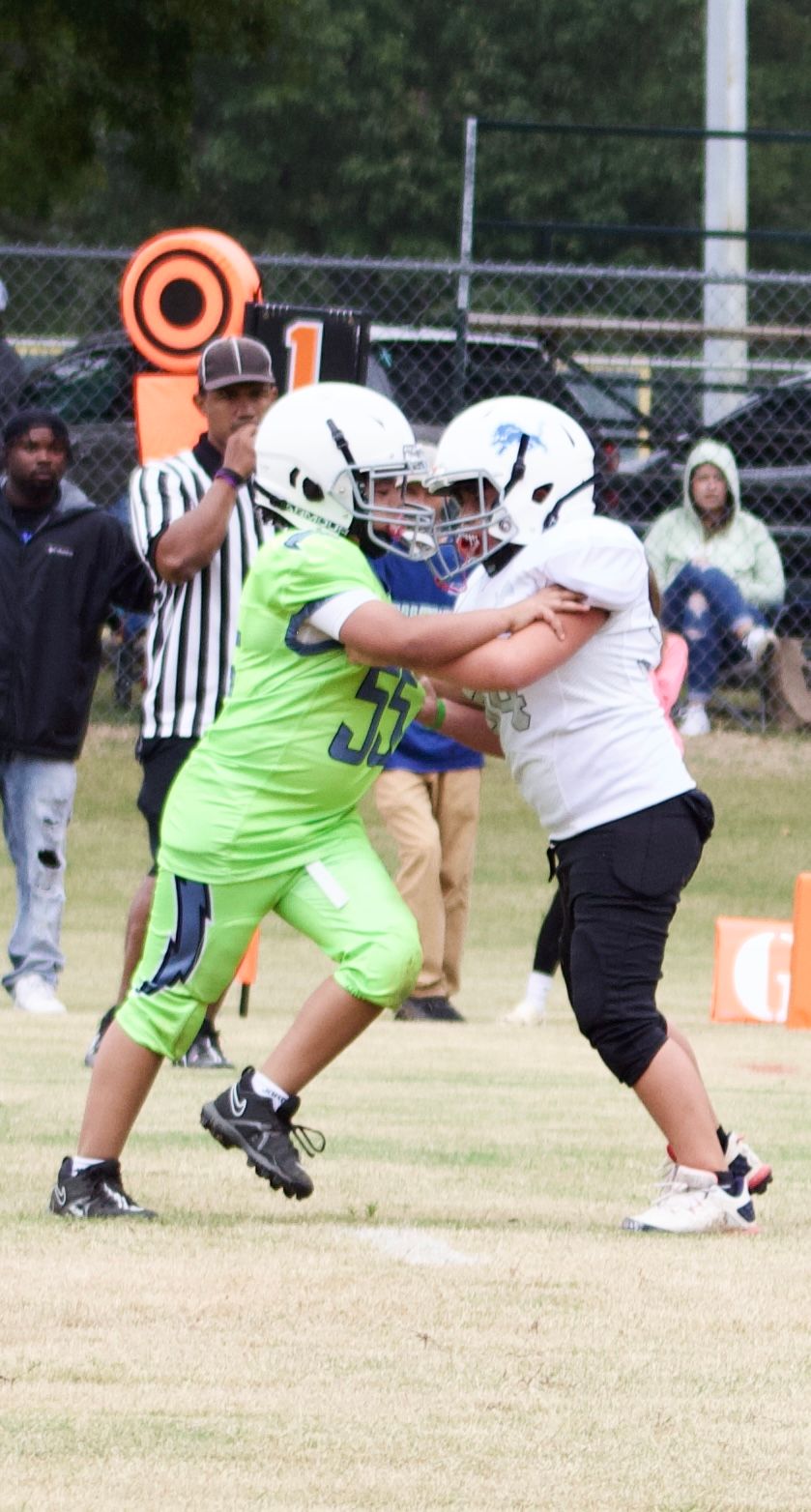 Travel football players making contact in an offense/defense style.