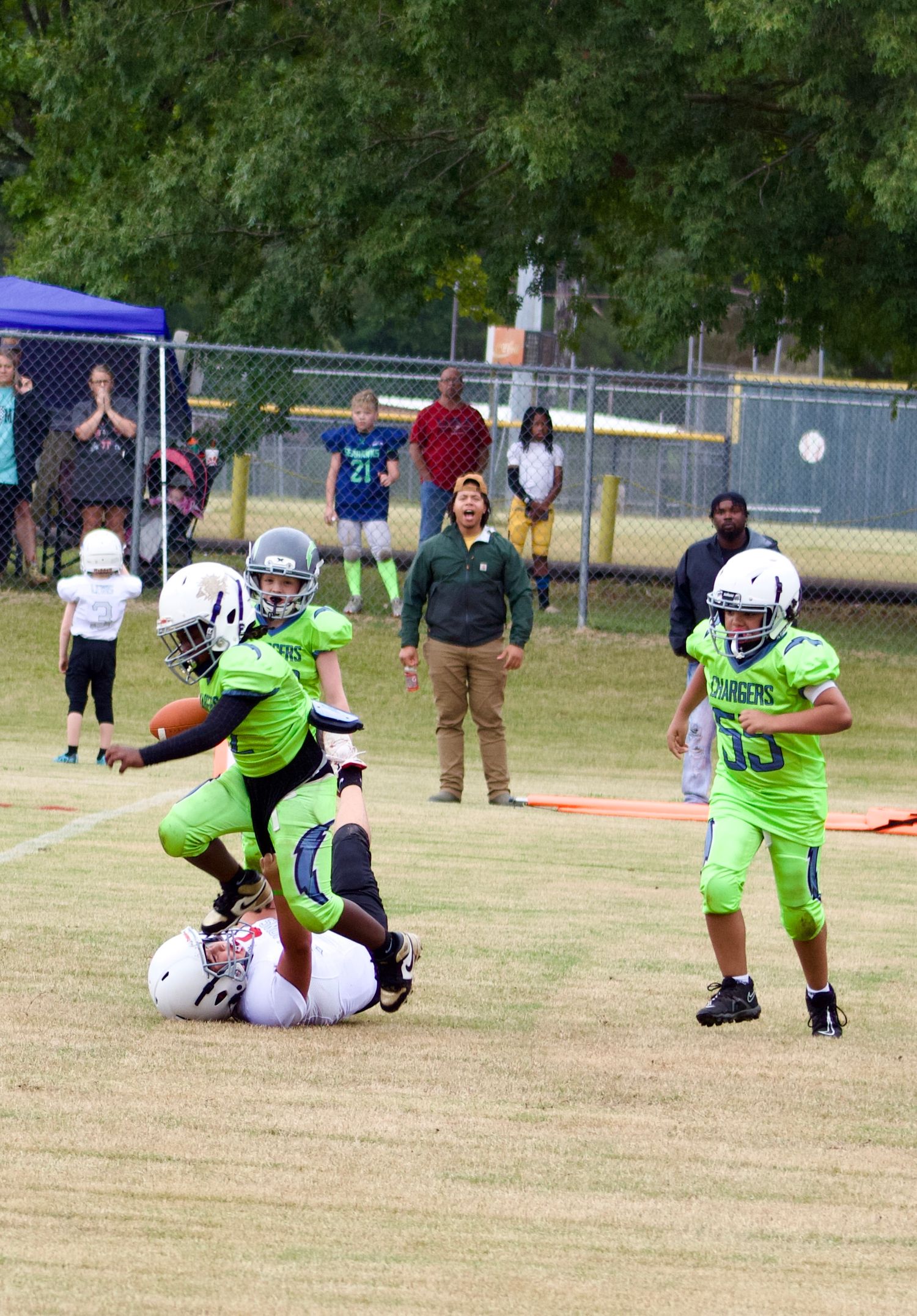 Little league player stepping on the helmet of the opposing team's player.