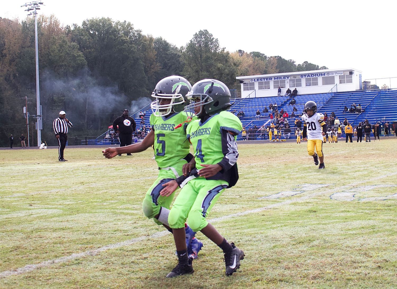 2 little league players running in to celebrate their victory at play offs.