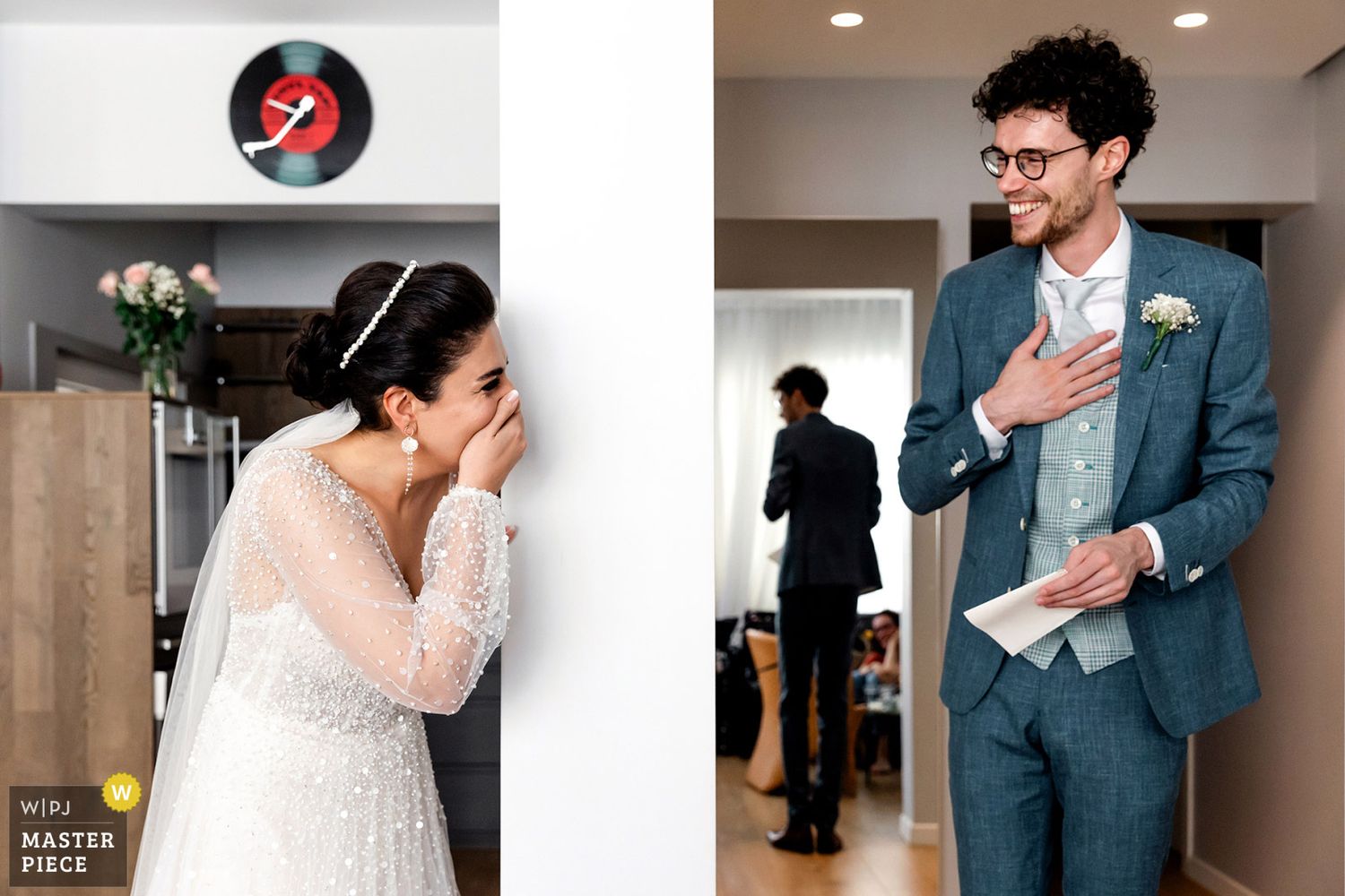 WPJA award-winning split-perspective photo of a laughing bride hiding behind a wall during a sweet first look with her groom.