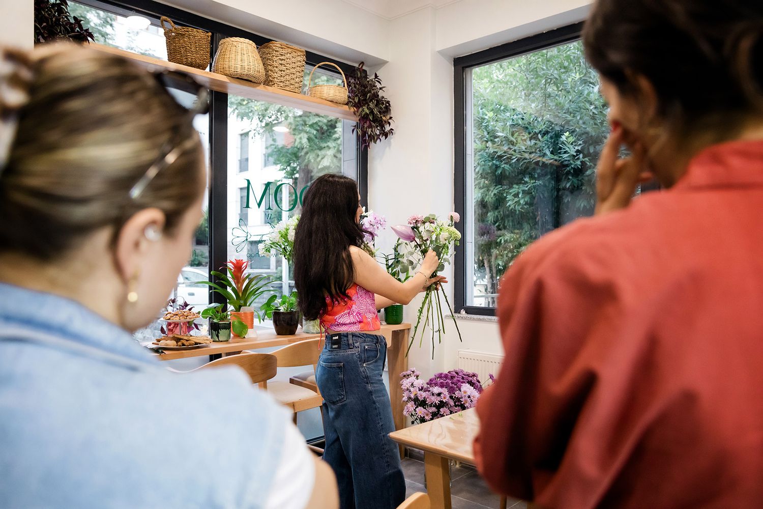 An instructor demonstrating floral arrangement techniques to attendees during an interactive boutique brand activation workshop.