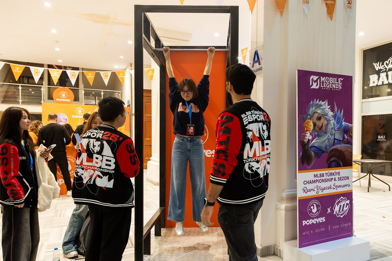 A female attendee participating in a physical pull-up challenge at an interactive sponsor brand activation booth.