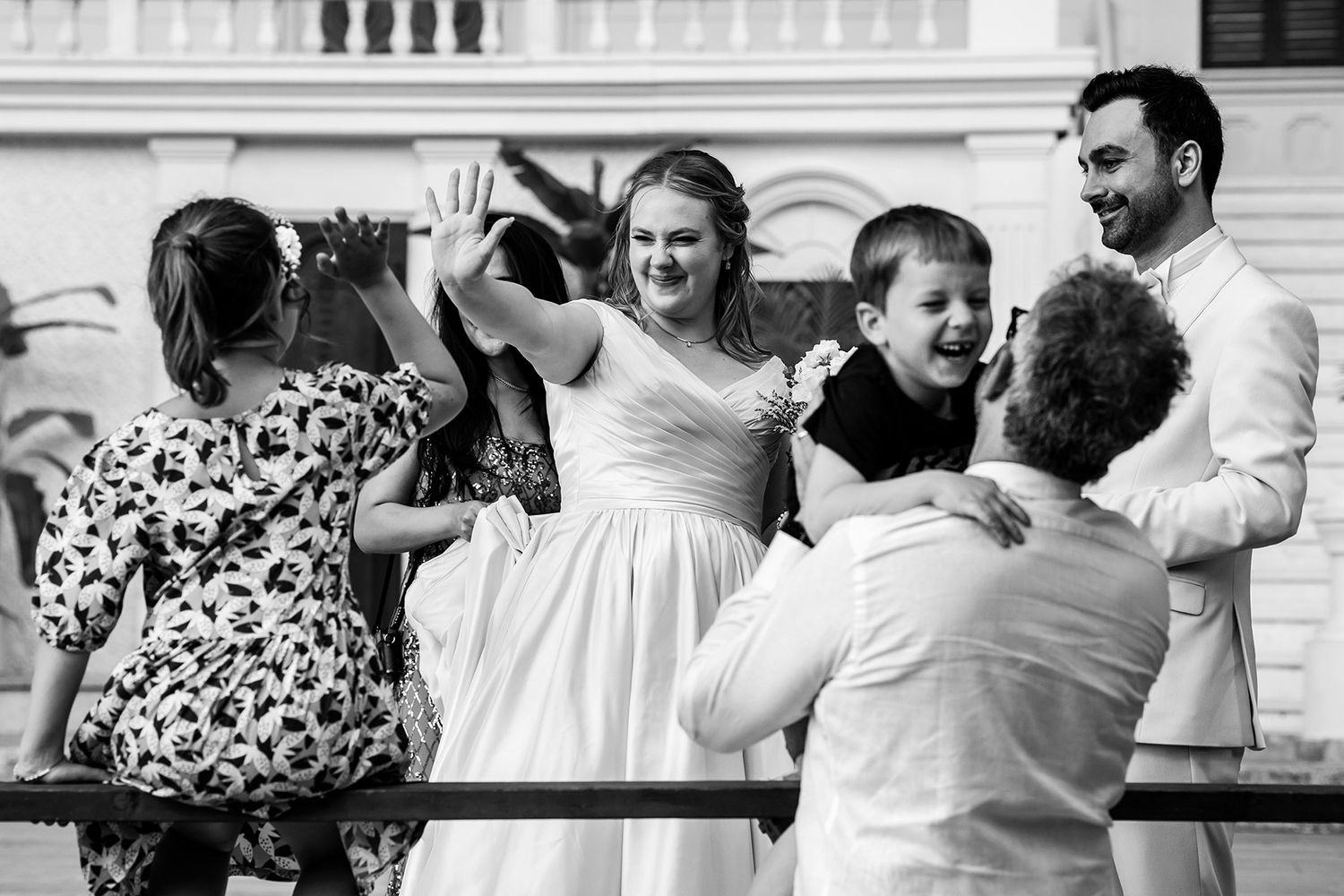 Heartwarming, unscripted black and white shot of a bride high-fiving a child during a joyful wedding celebration in Sarıyer Korusu.