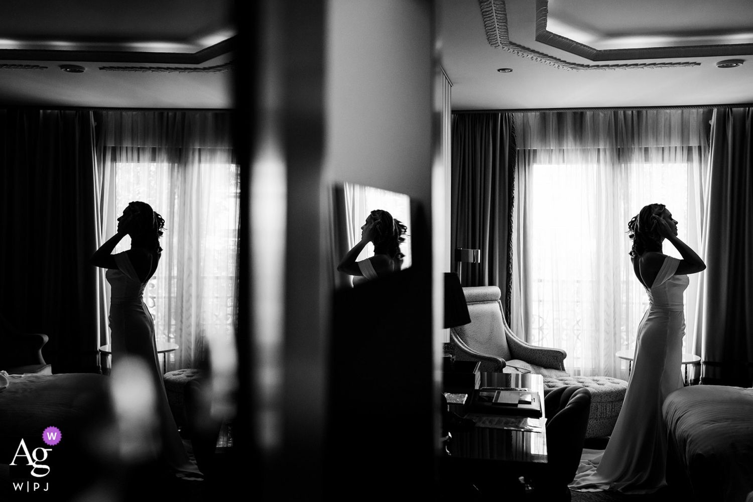 AG WPJA award-winning black and white creative reflection shot of a bride putting on earrings in her elegant hotel room.