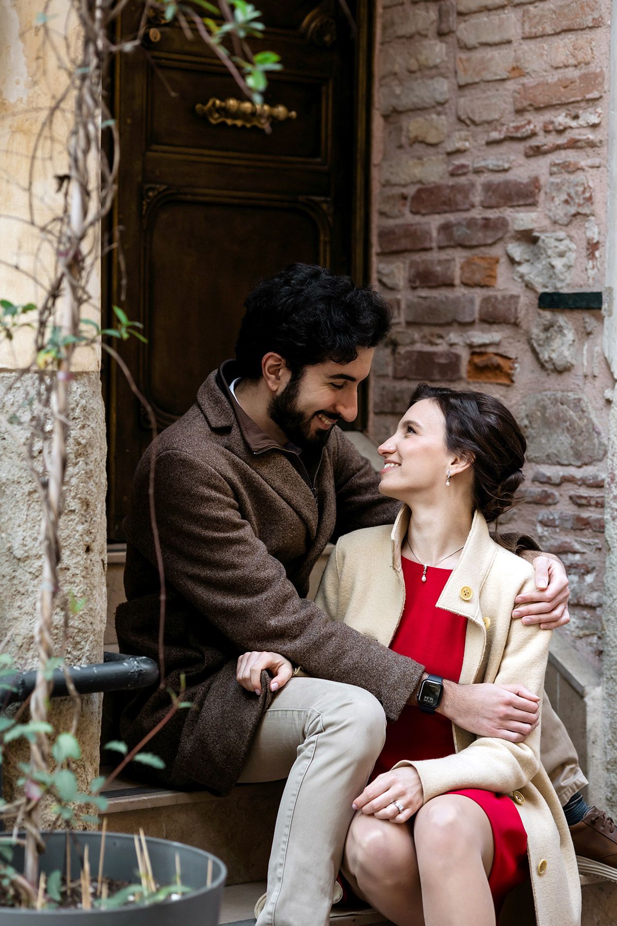 A couple sharing a candid, intimate moment while sitting and hugging on historic stone steps in the backstreets of Beyoğlu, Istanbul.