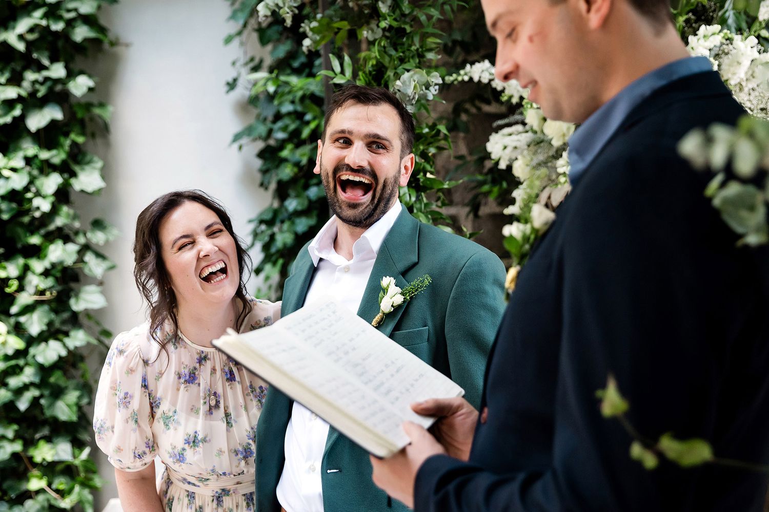 A bride and groom laugh hysterically out loud during their intimate, unscripted British wedding ceremony at Aslı Tunca in Istanbul.