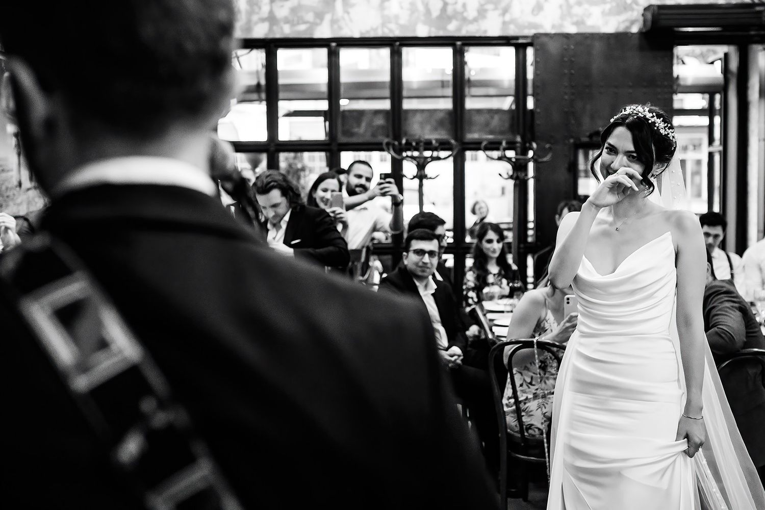 An emotional bride wipes away tears of joy while looking at her groom during an intimate, unscripted wedding reception in Istanbul.