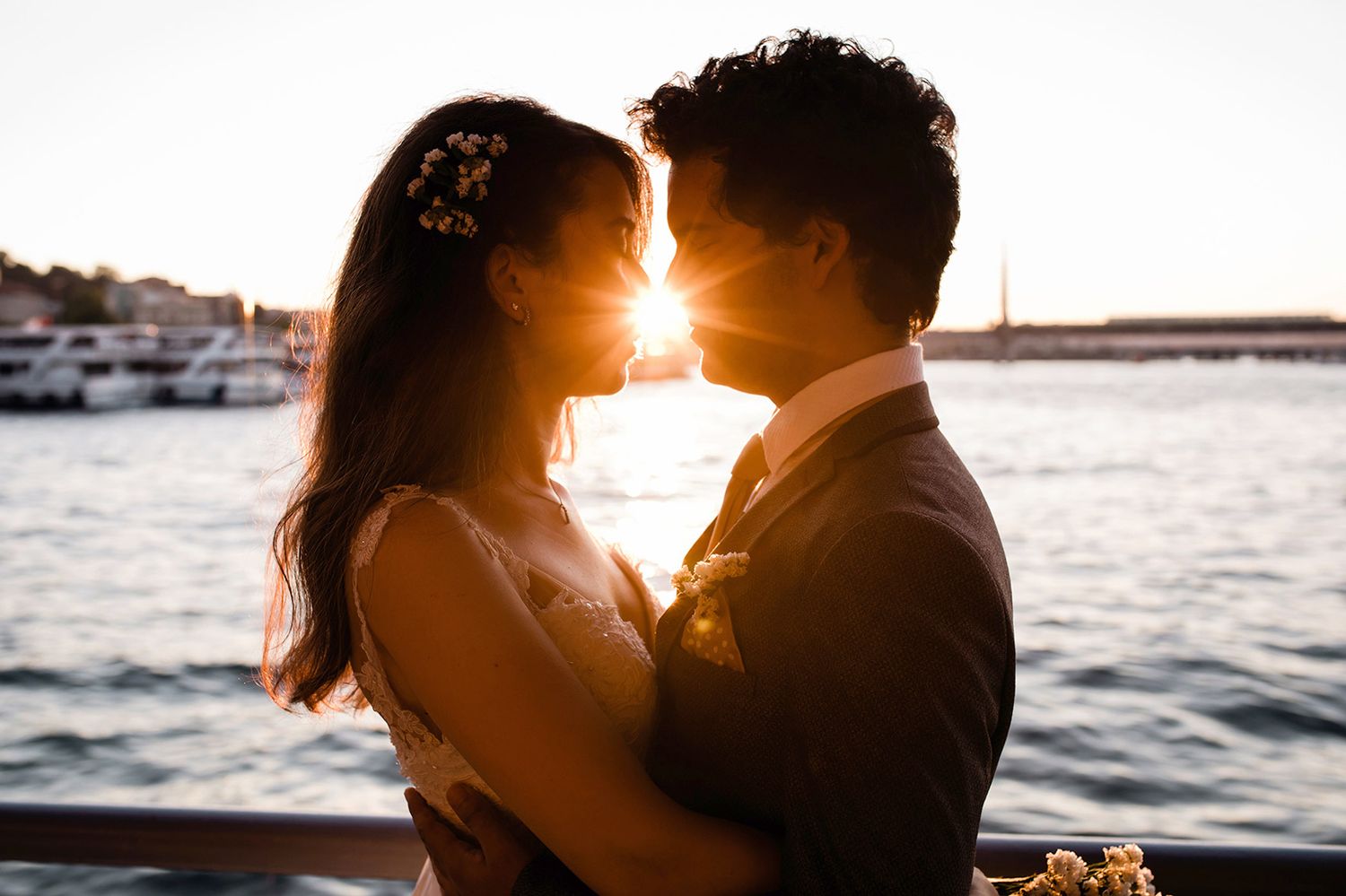 A close-up silhouette of a bride and groom leaning in for a kiss with golden hour sun flare catching perfectly between them in Istanbul.