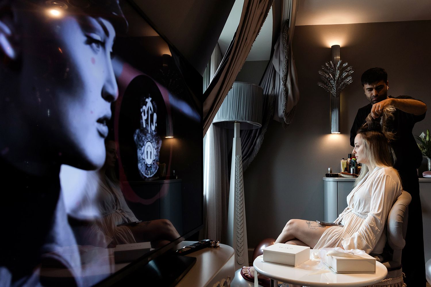 Moody, documentary portrait of a bride getting her hair styled during wedding prep at the Wyndham Grand Kalamış in Istanbul.