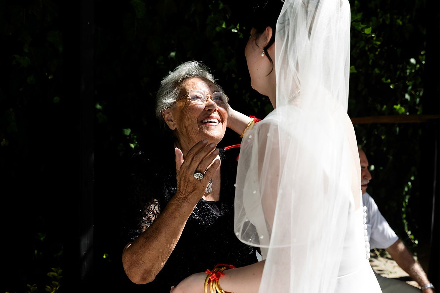 Heartwarming documentary photo of a grandmother lovingly touching the bride's face during an emotional wedding moment at Yanık Mektep.