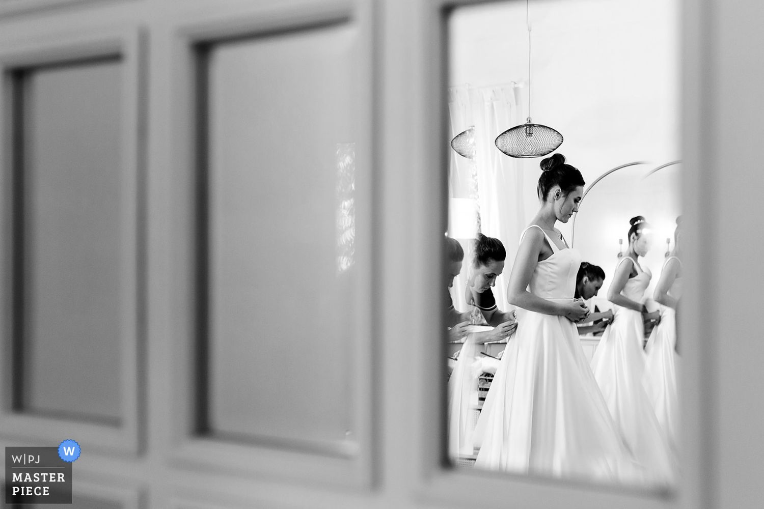 WPJA Masterpiece award-winning black and white creative reflection of a bride getting buttoned into her dress during prep.
