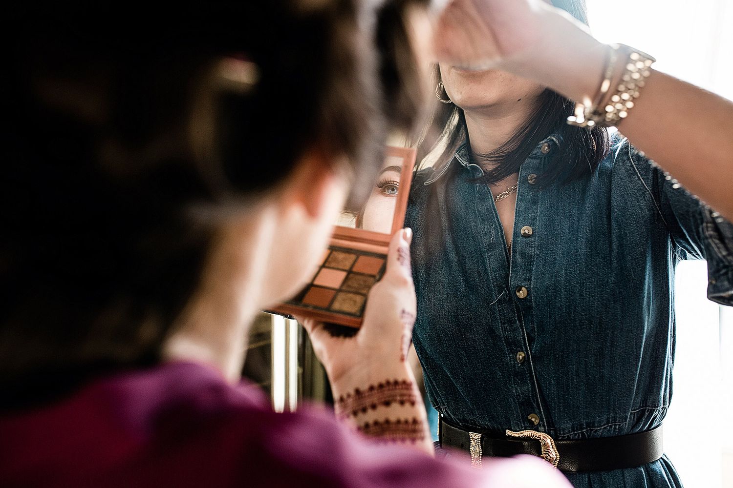 Documentary reflection shot of a bride getting makeup done during her wedding prep at the historic Pera Palace Hotel in Istanbul.