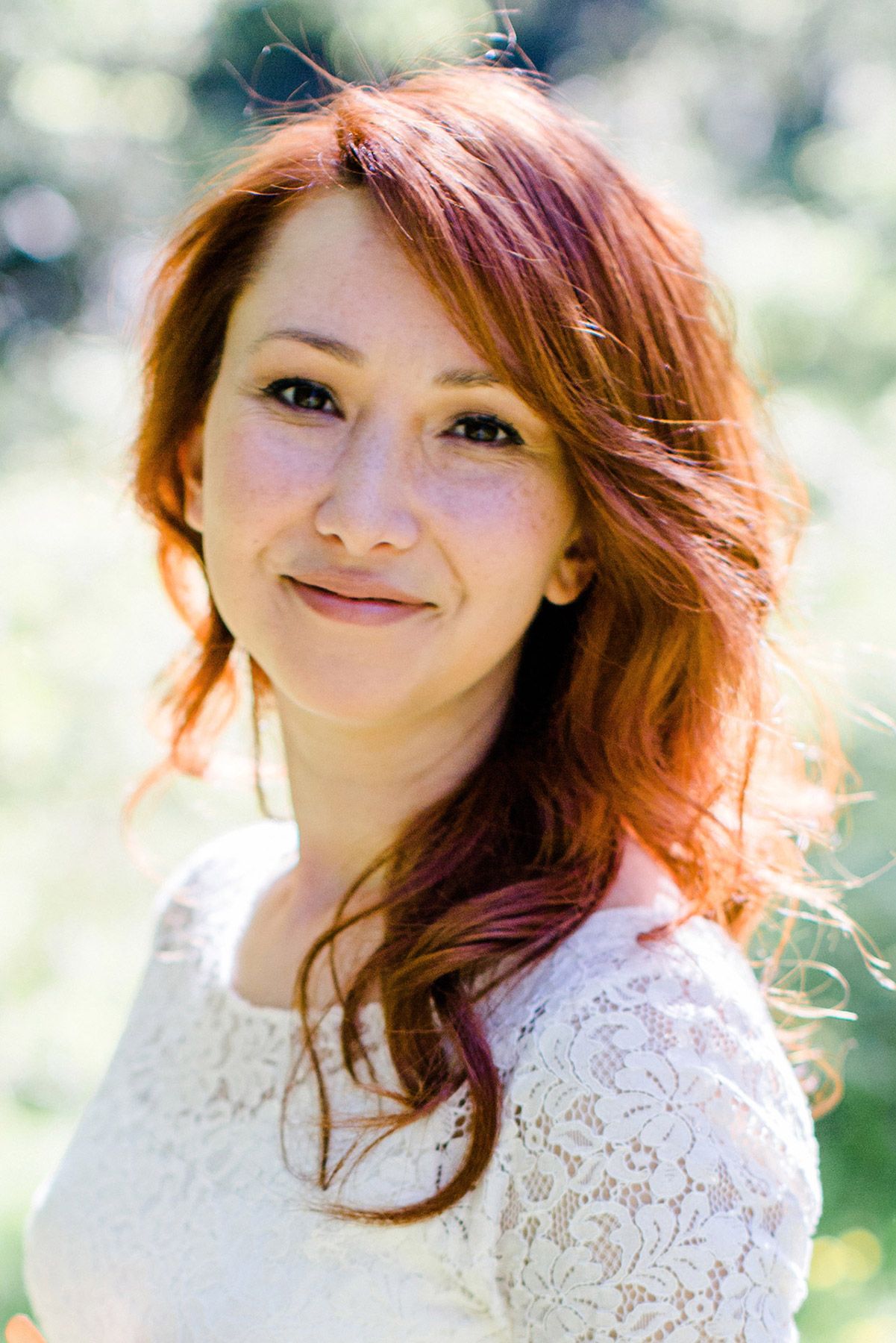 Portrait of Nilüfer Nalbantoğlu, an award-winning documentary wedding and event photographer based in Istanbul, smiling warmly outdoors.