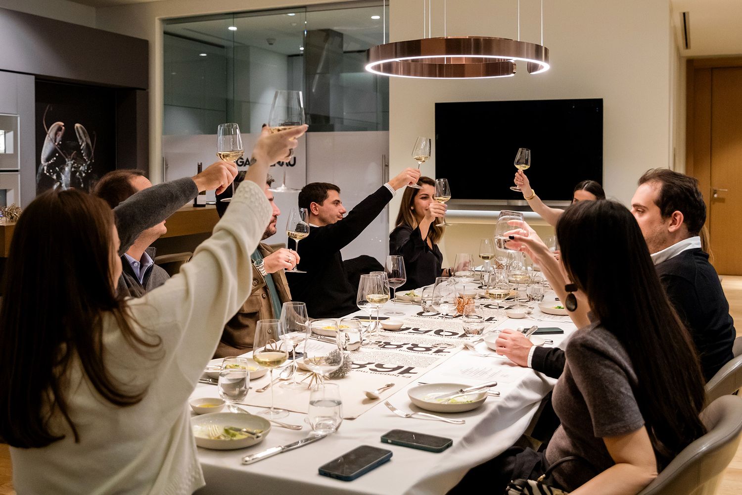 Guests raising wine glasses for a celebratory toast at an exclusive Gaggenau corporate dinner event in Istanbul.