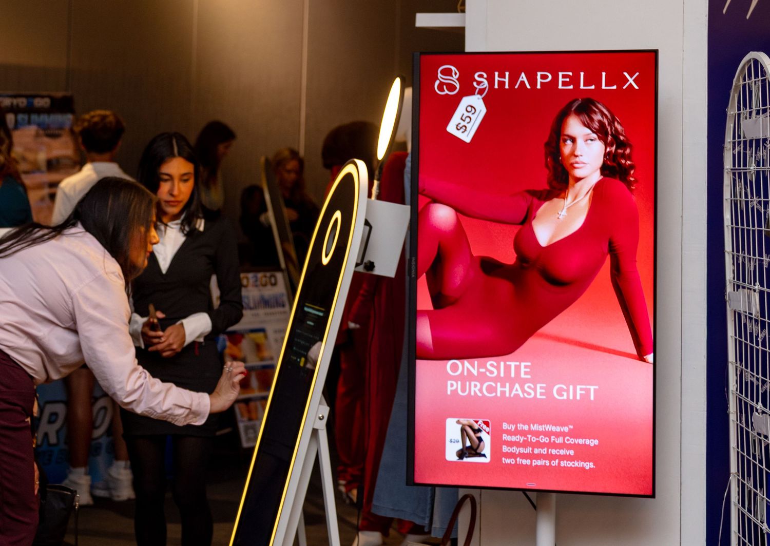 Shapellx brand display at a trade show event with digital signage advertising on-site purchase gifts.