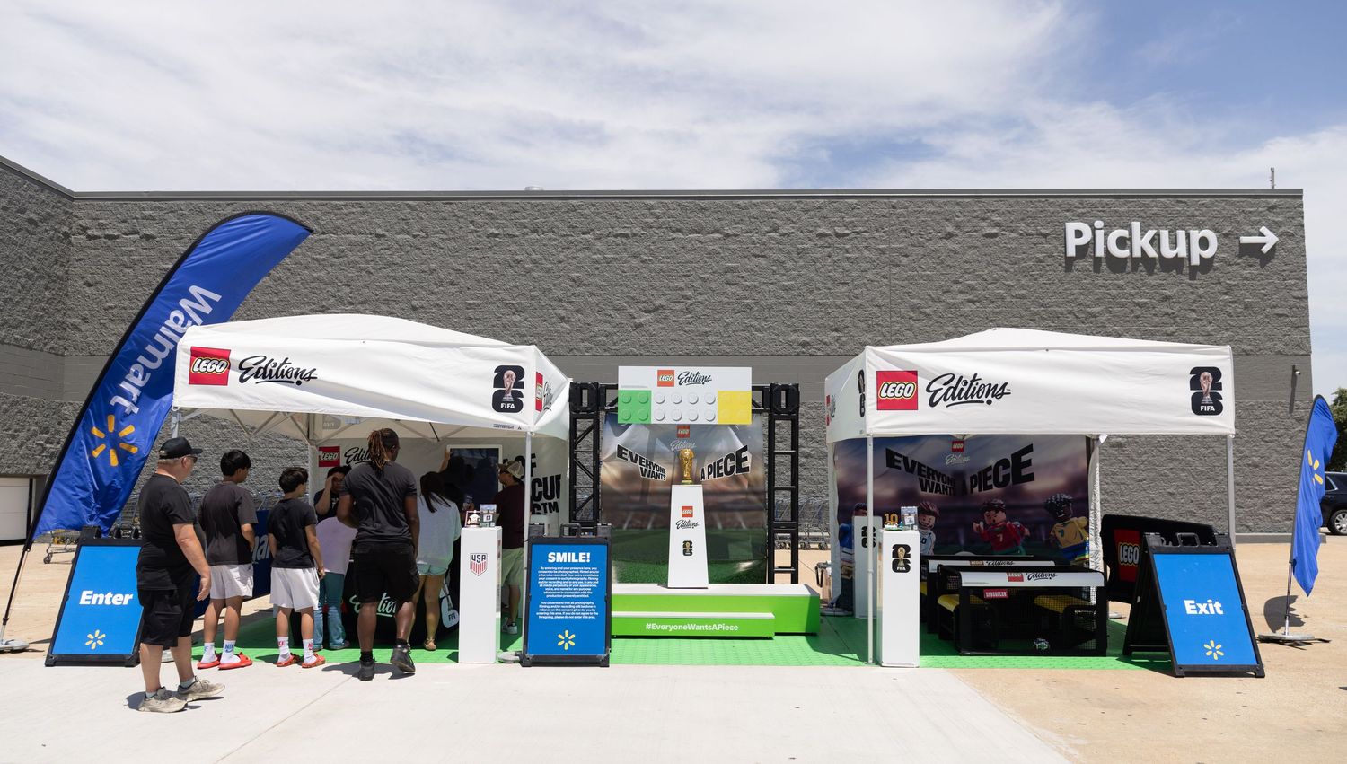 Outdoor LEGO Editions event booths with Enter and Exit signs outside a Walmart pickup location.