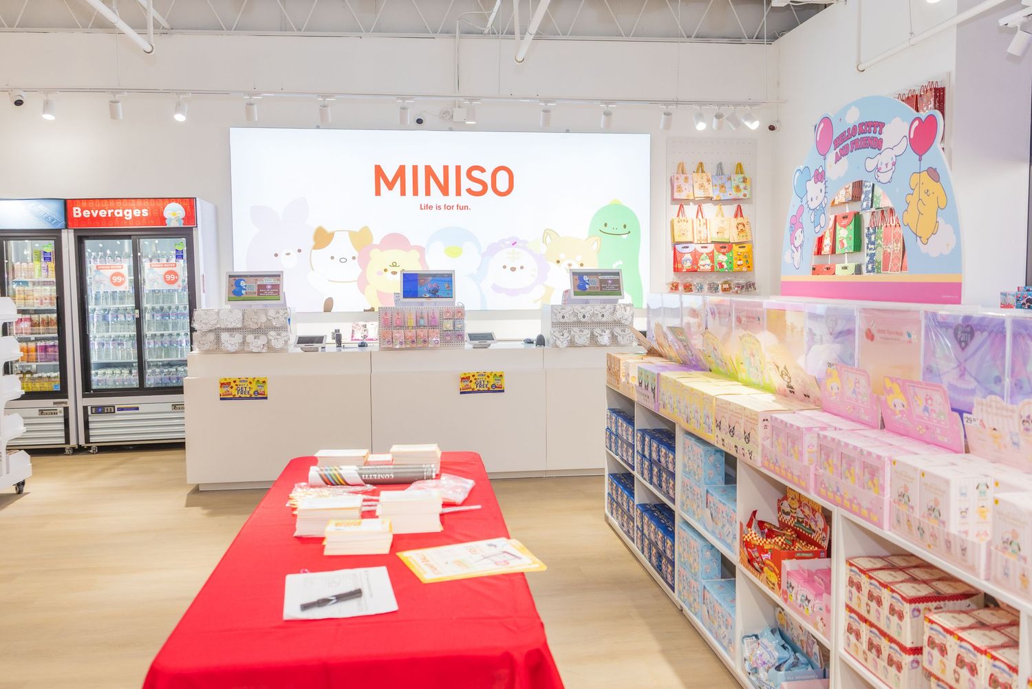 MINISO store interior with branded red shopping baskets, product shelves, and a large logo on the wall.